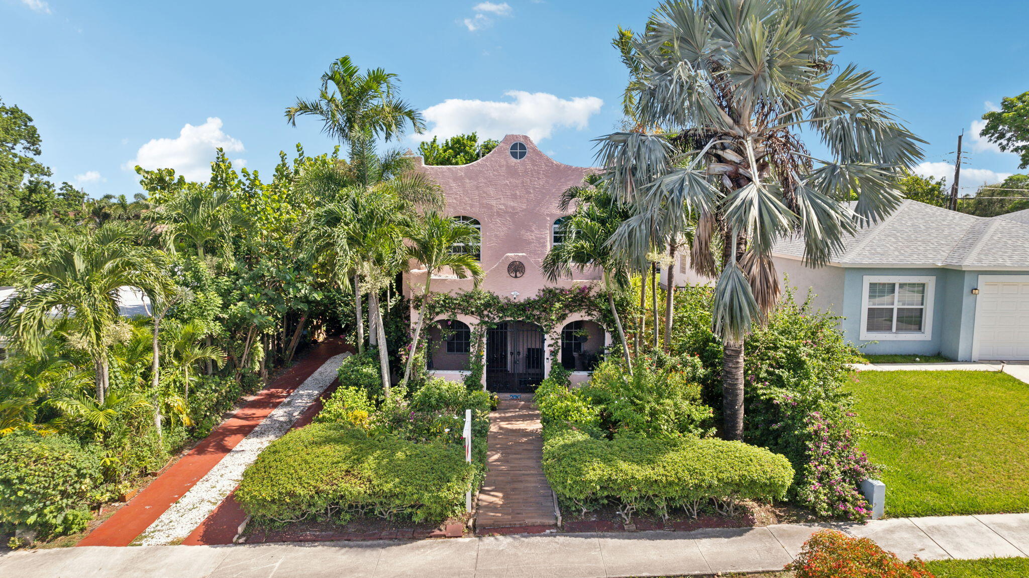 a front view of a house with a yard and potted plants