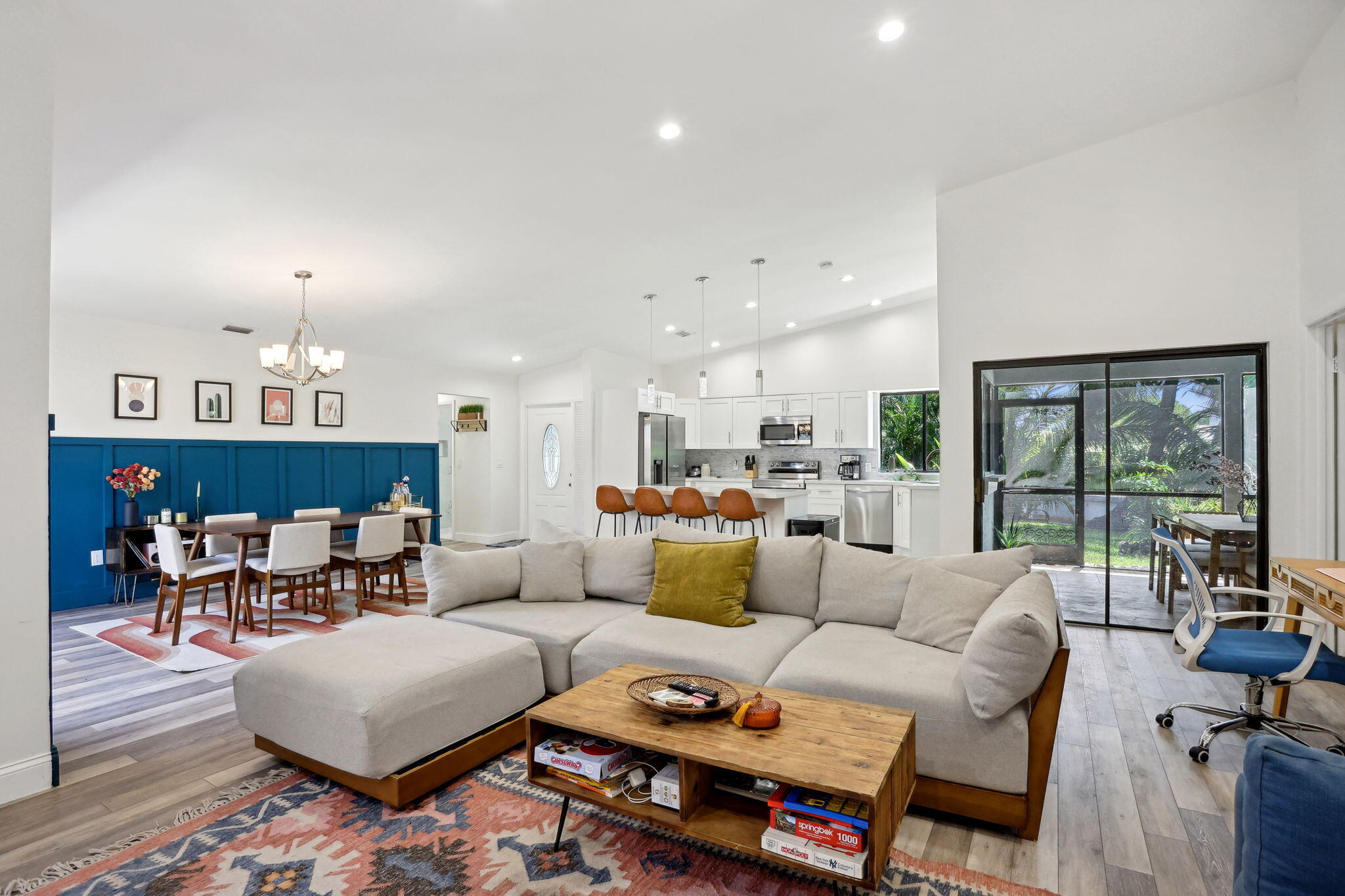 a living room with furniture and a dining table with wooden floor