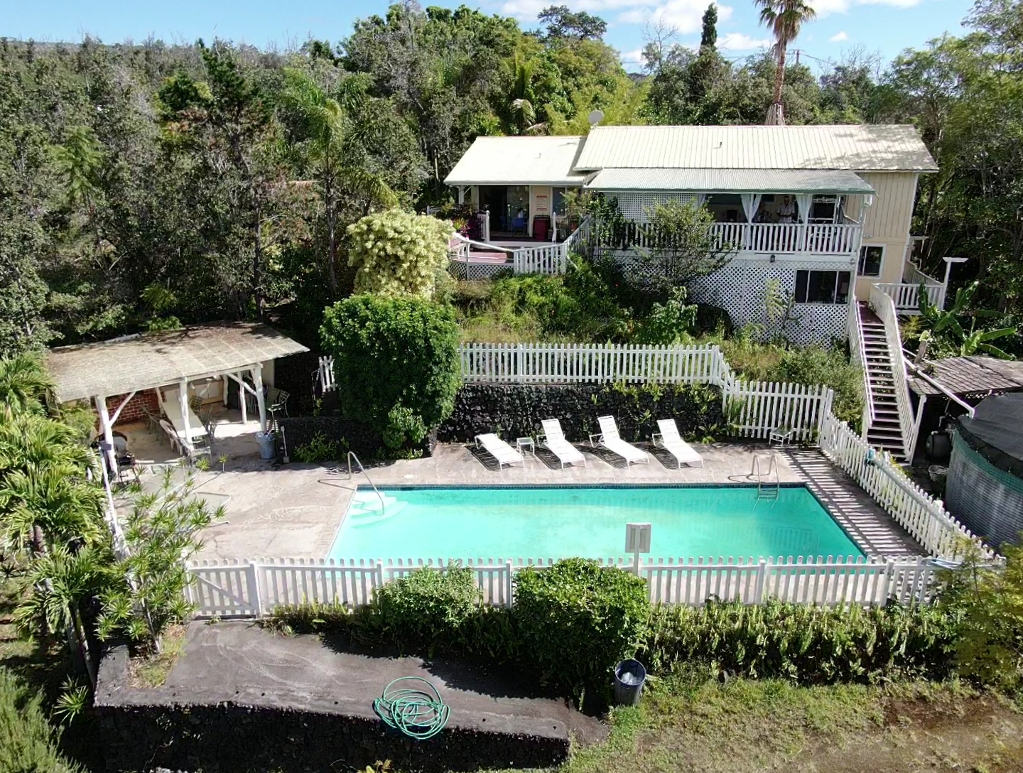 a view of a house with pool and chairs