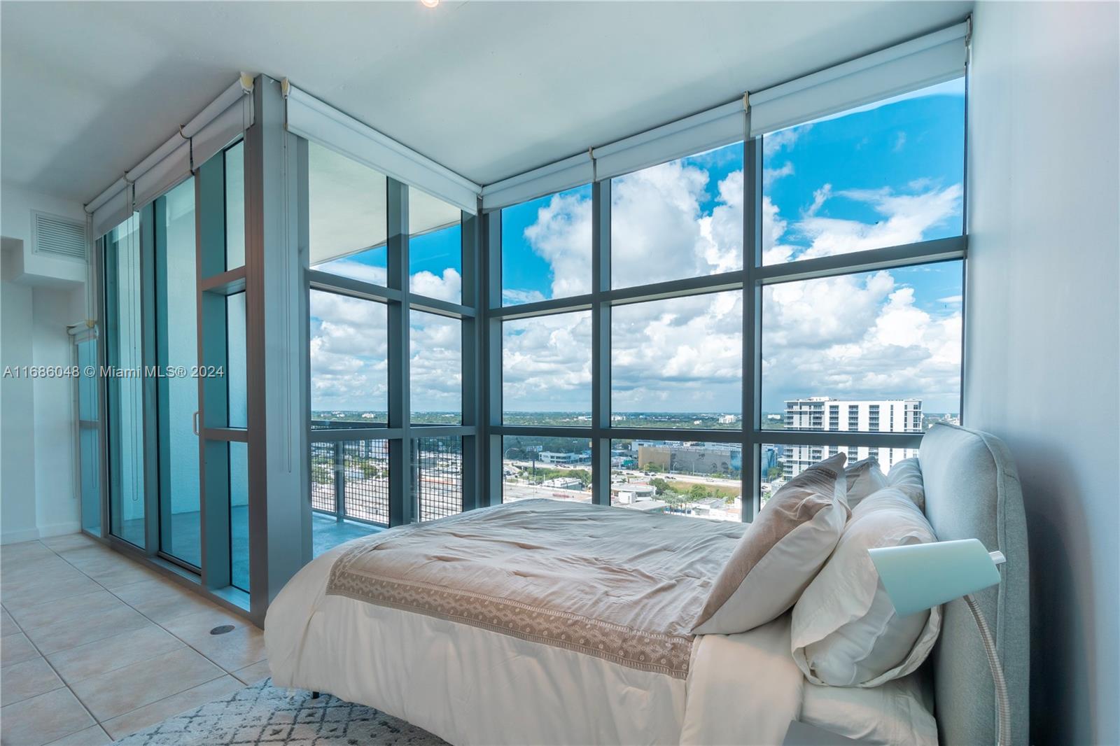 a bedroom with a bed and a large window