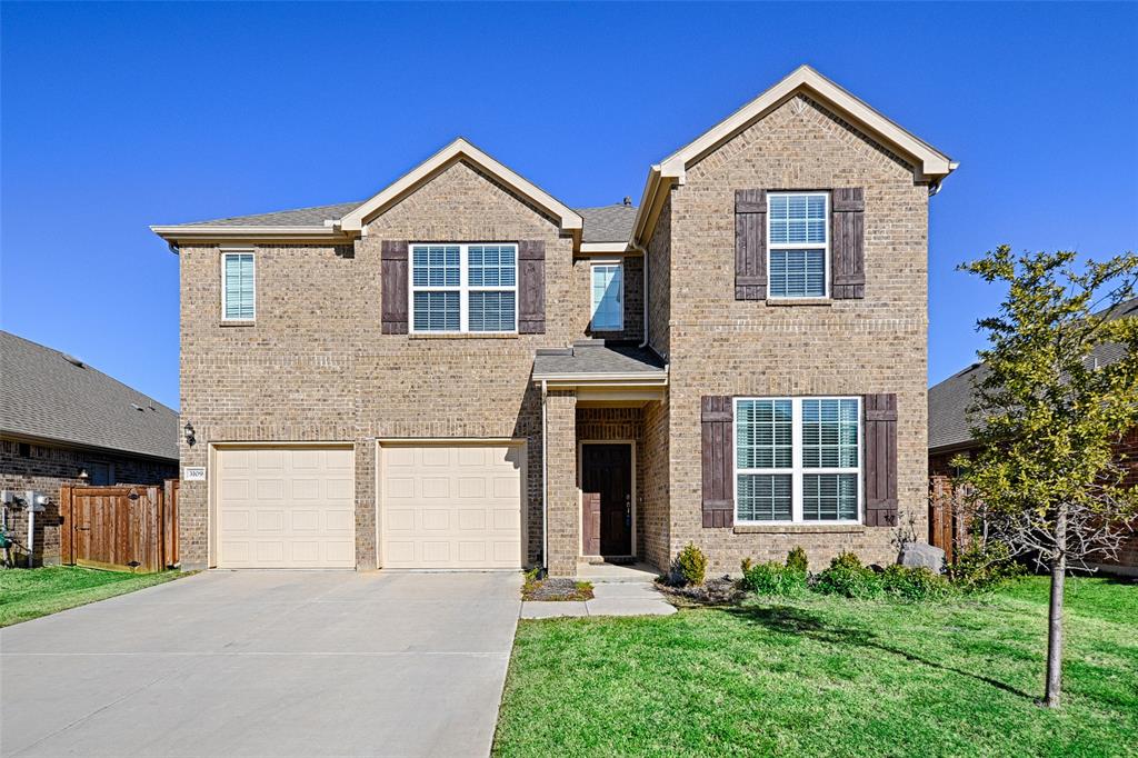 View of front of home with a front yard and a garage