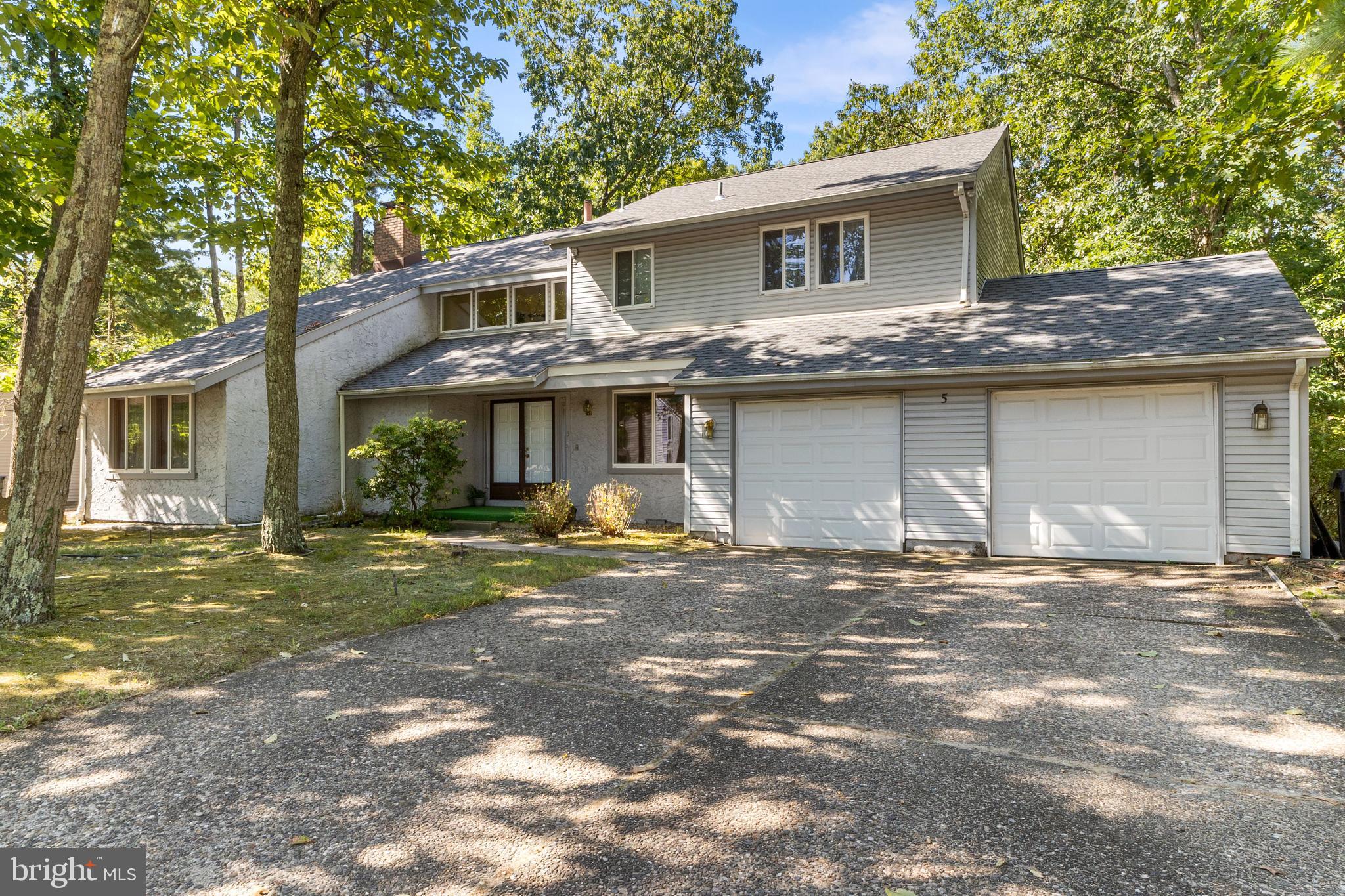 a view of a house with a yard and large tree