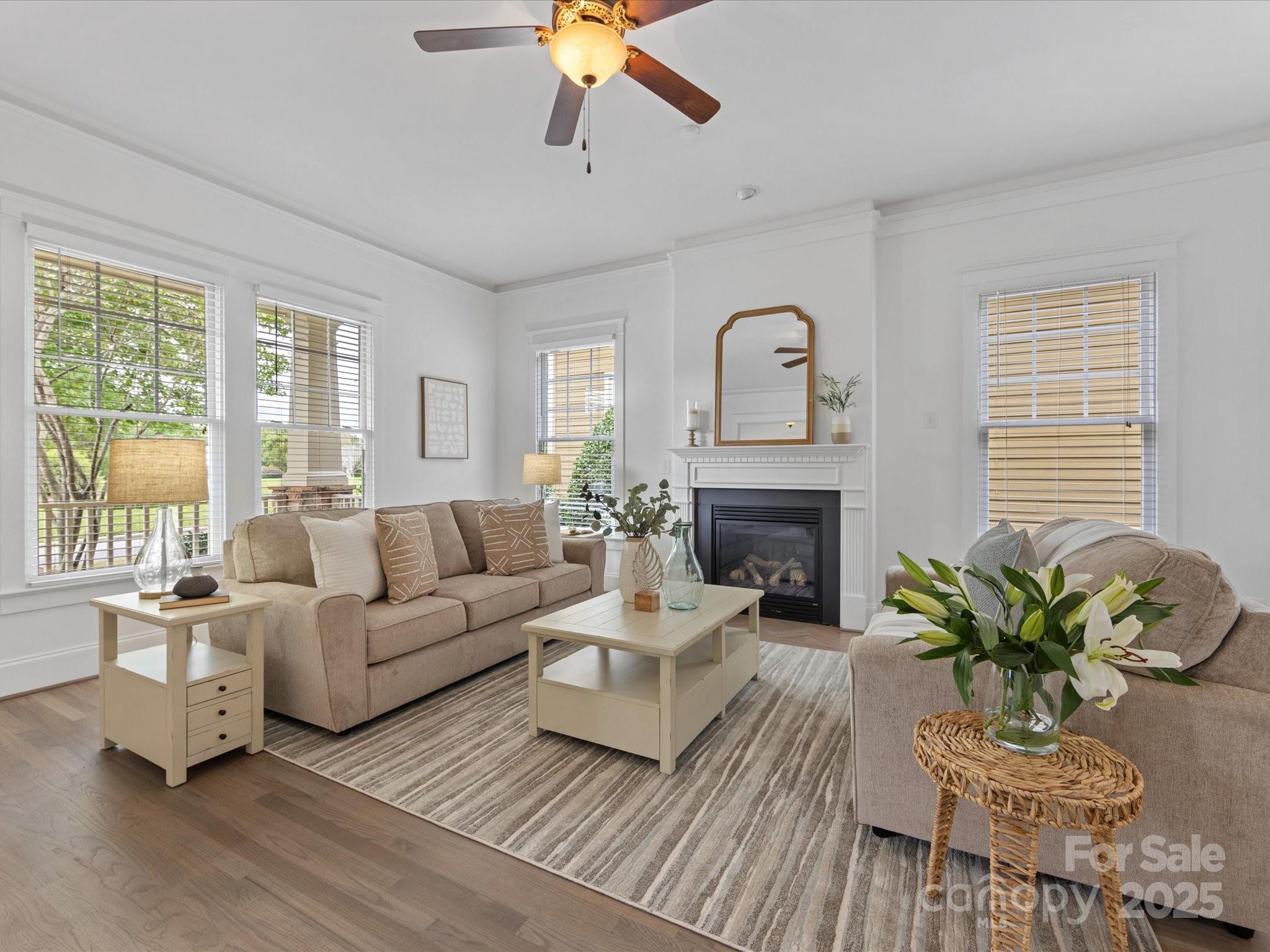 a living room with furniture fireplace and a large window