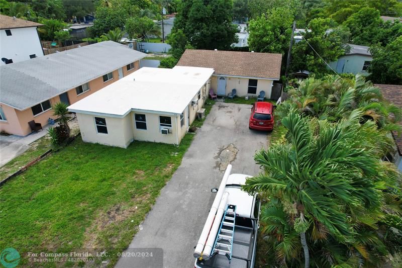 an aerial view of a house with a yard table and chairs