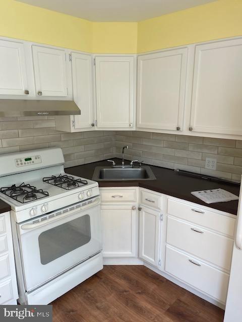 a kitchen with white cabinets and appliances