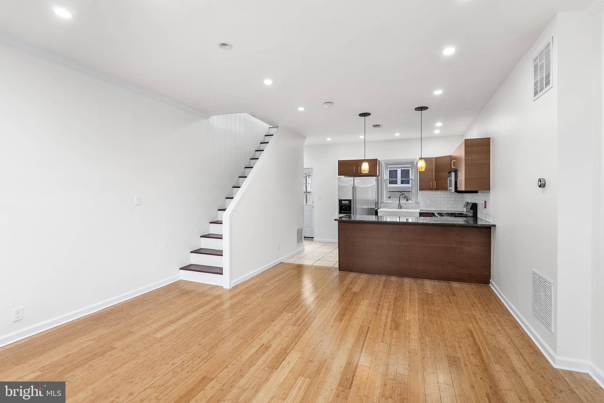 a view of kitchen with wooden floor and electronic appliances