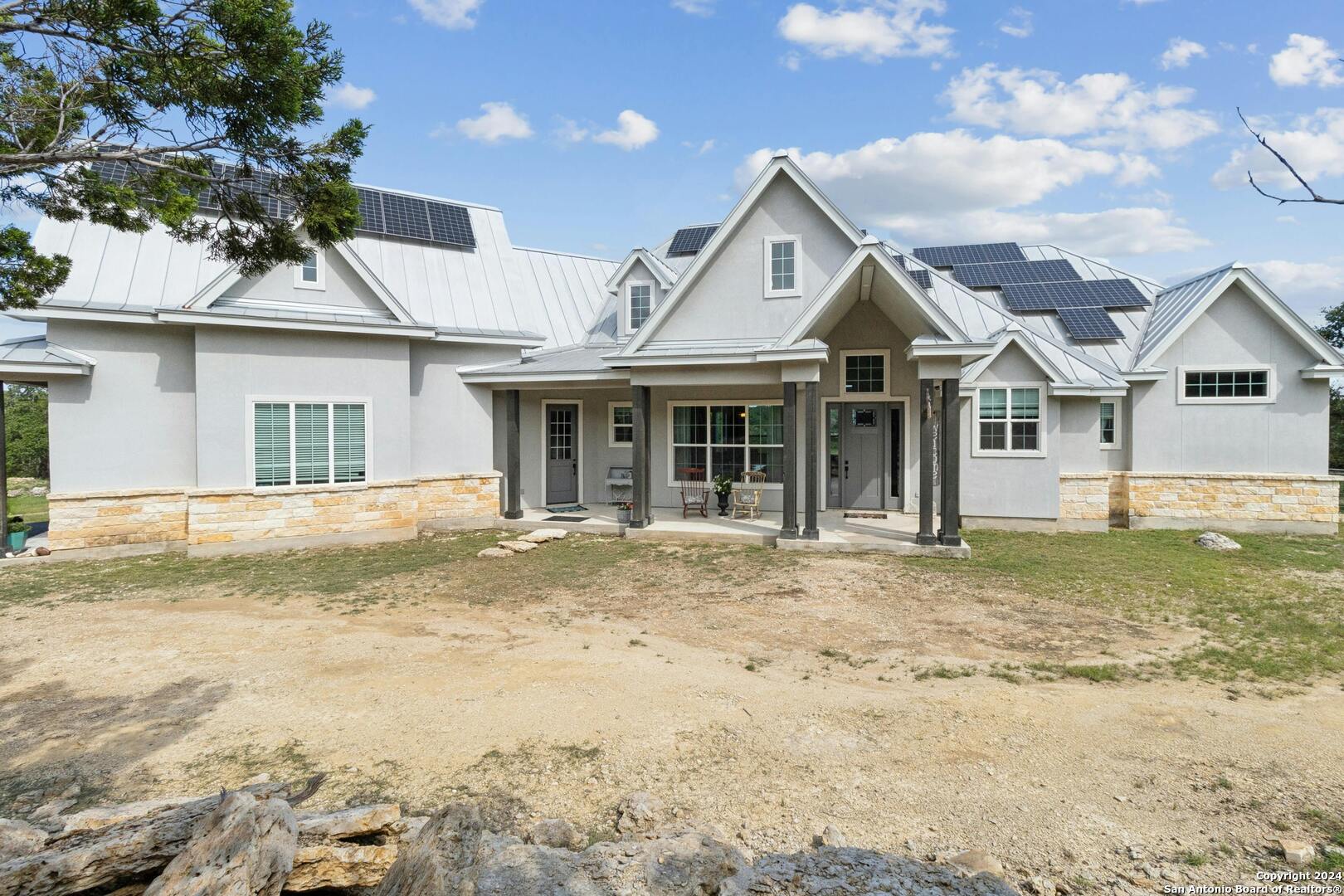 a front view of a house with a garden and yard