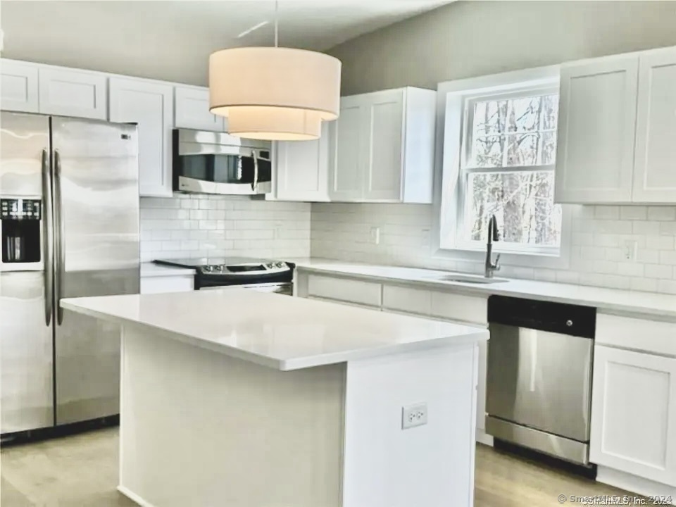 a kitchen with cabinets and a refrigerator