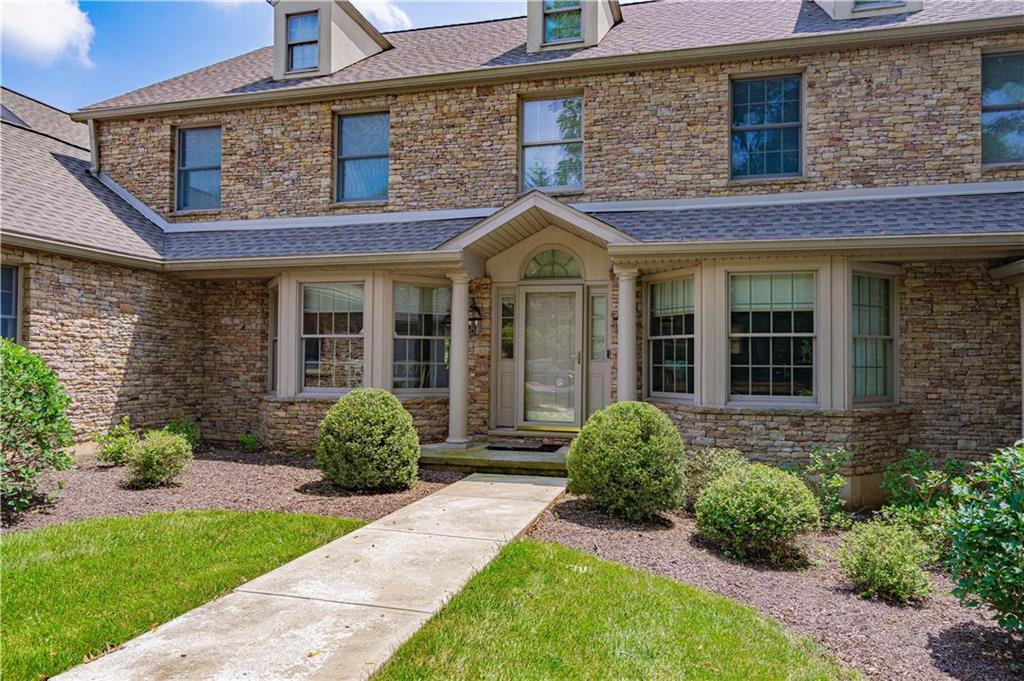 front view of a brick house with a yard