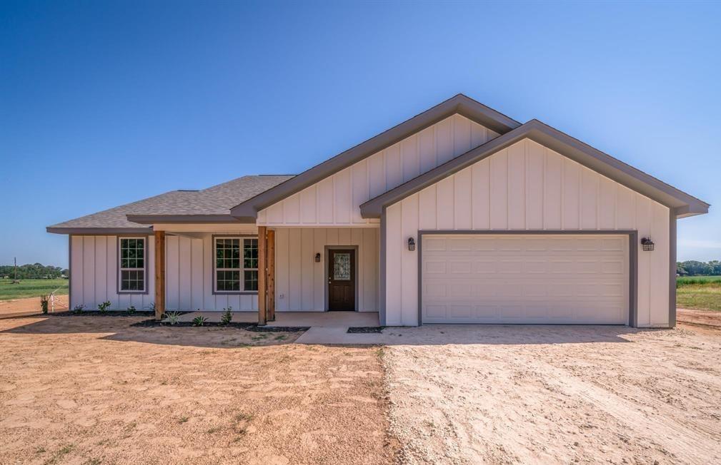 a view of house with yard and garage