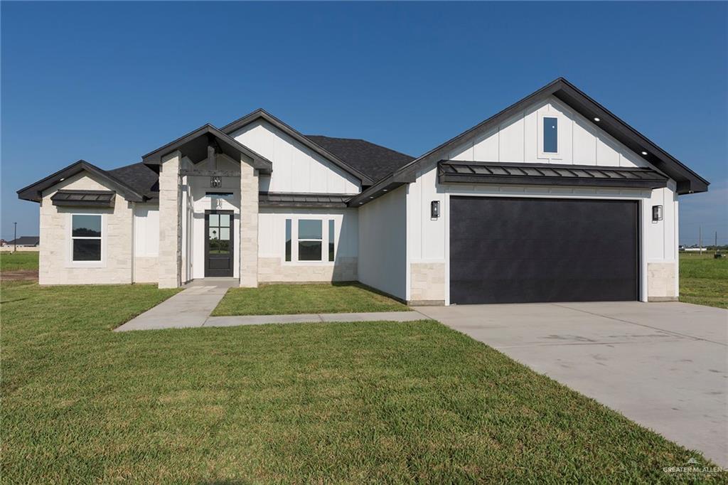 View of front of house with a front lawn and a garage