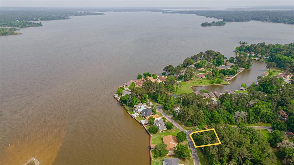 an aerial view of a house with a yard and lake view