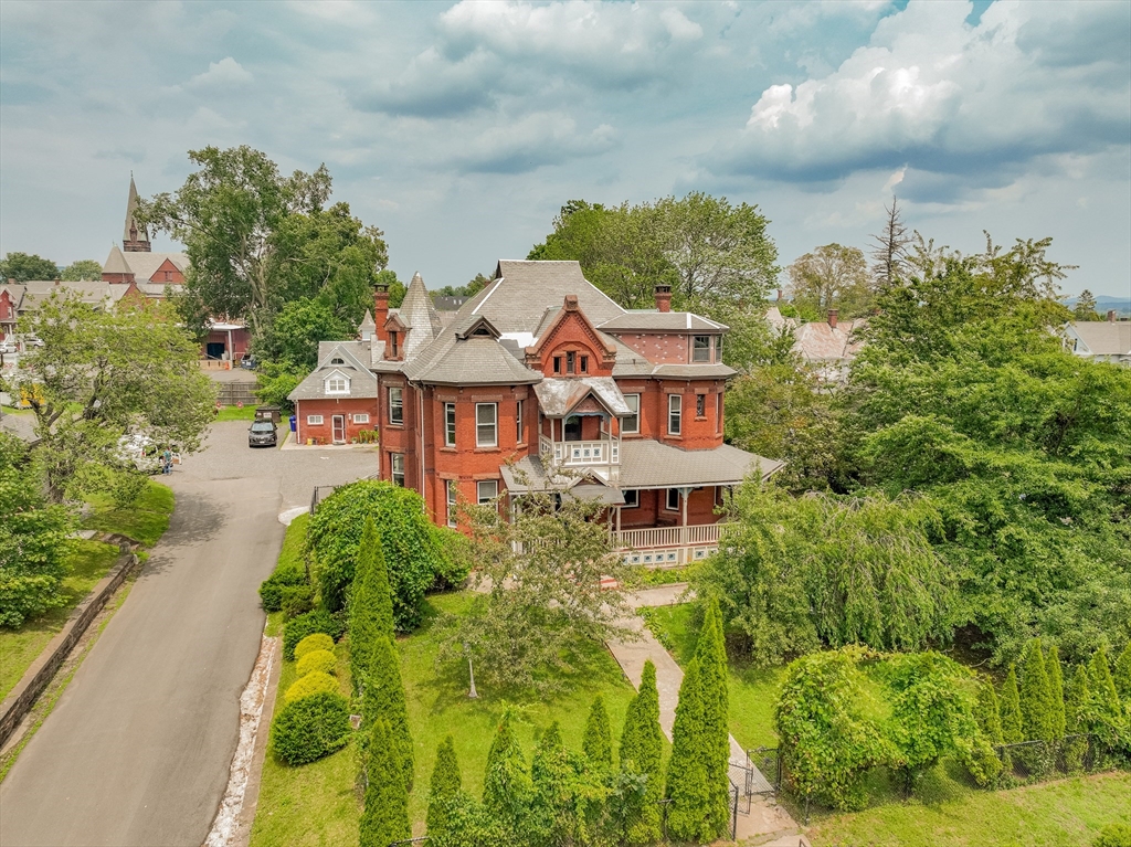 an aerial view of a house with swimming pool and garden space