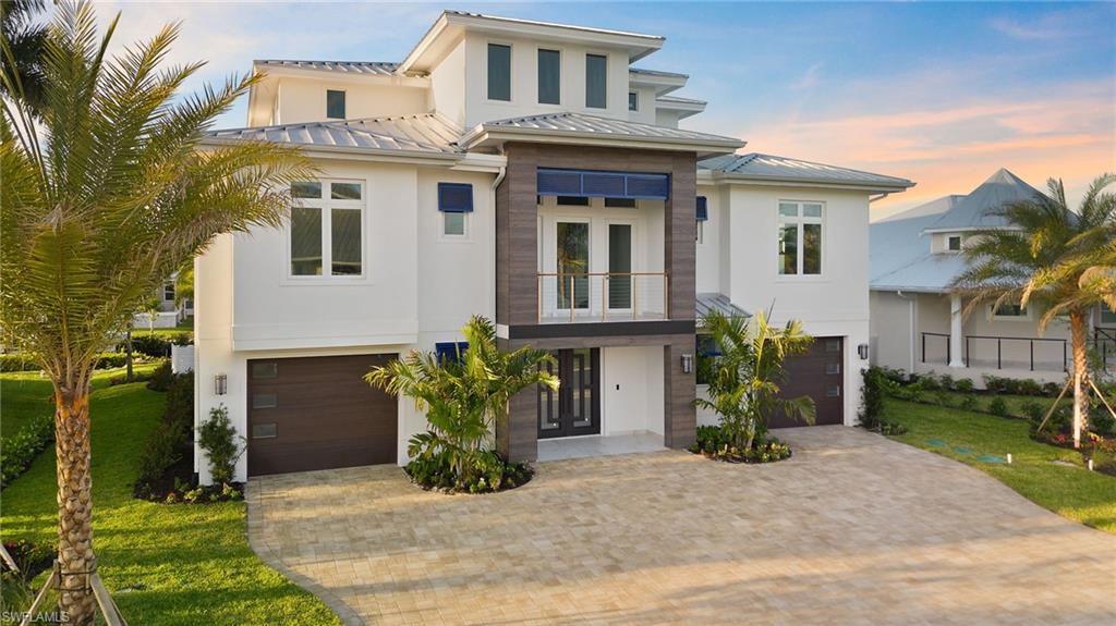 View of front of property with a garage, a yard, and french doors