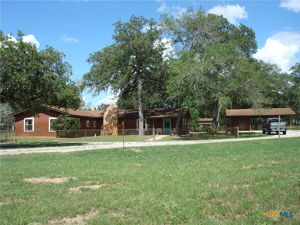 a front view of house with yard and trees