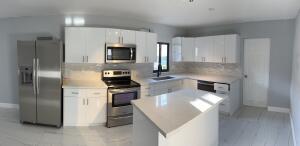 a kitchen with stainless steel appliances granite countertop a refrigerator a stove and a sink