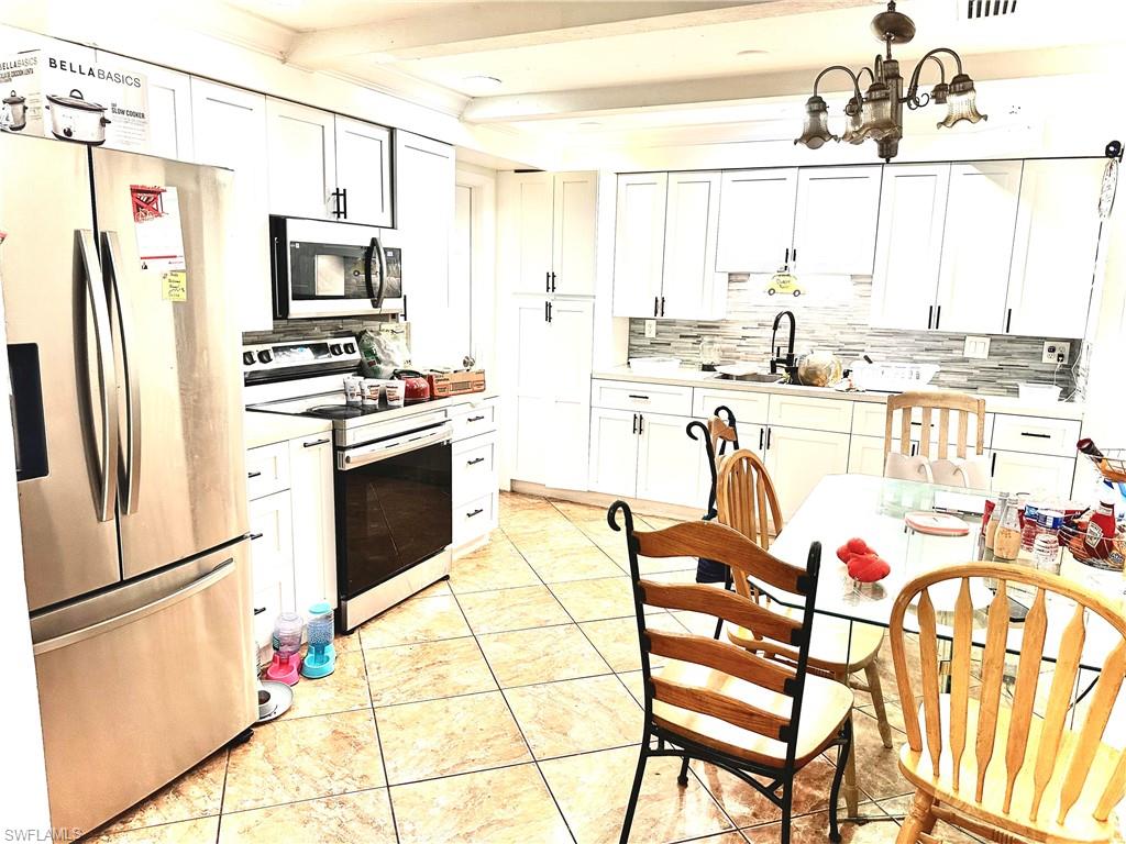 a kitchen with stainless steel appliances kitchen island granite countertop a refrigerator and a stove top oven