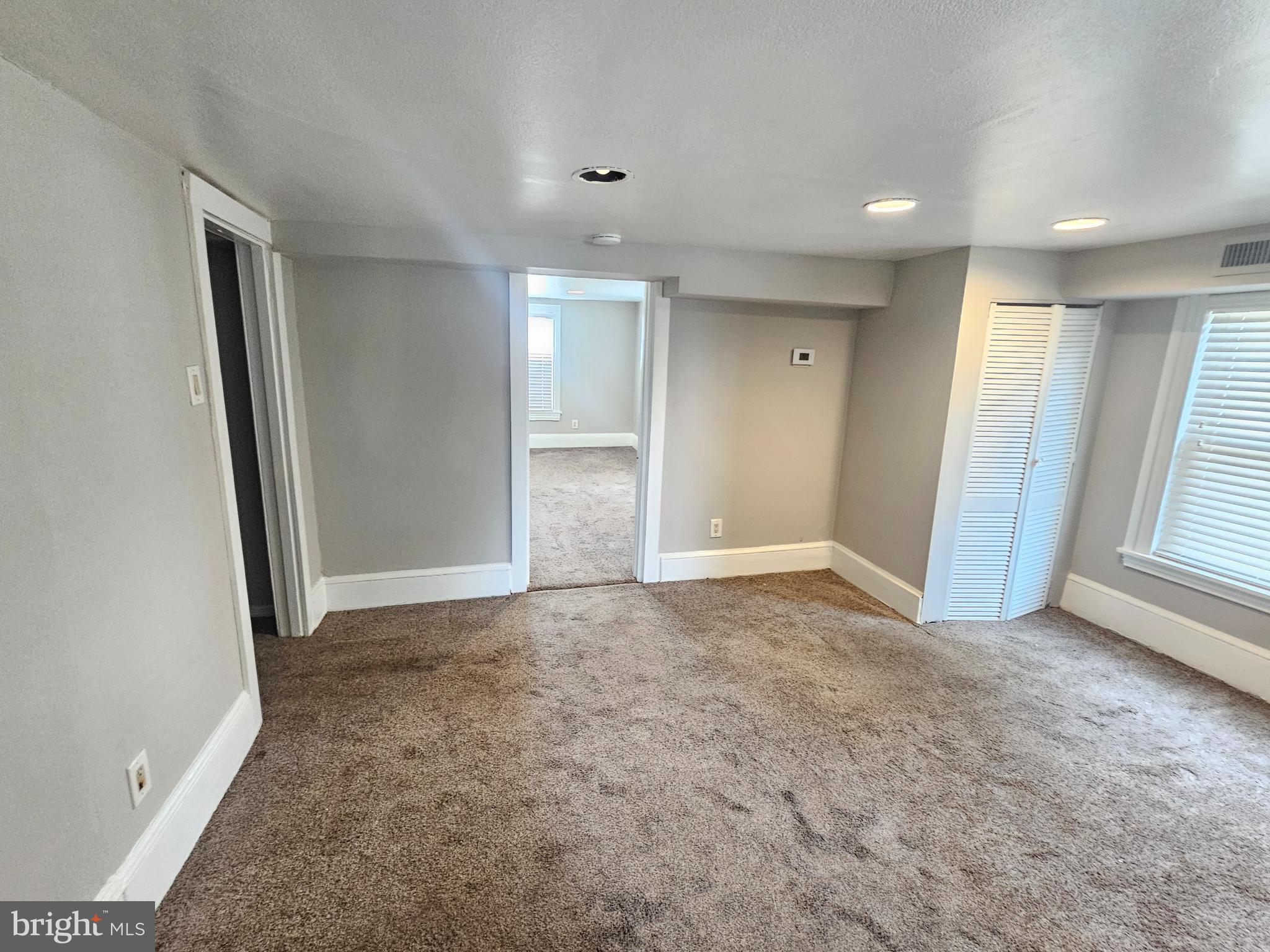 an empty room with windows and closet