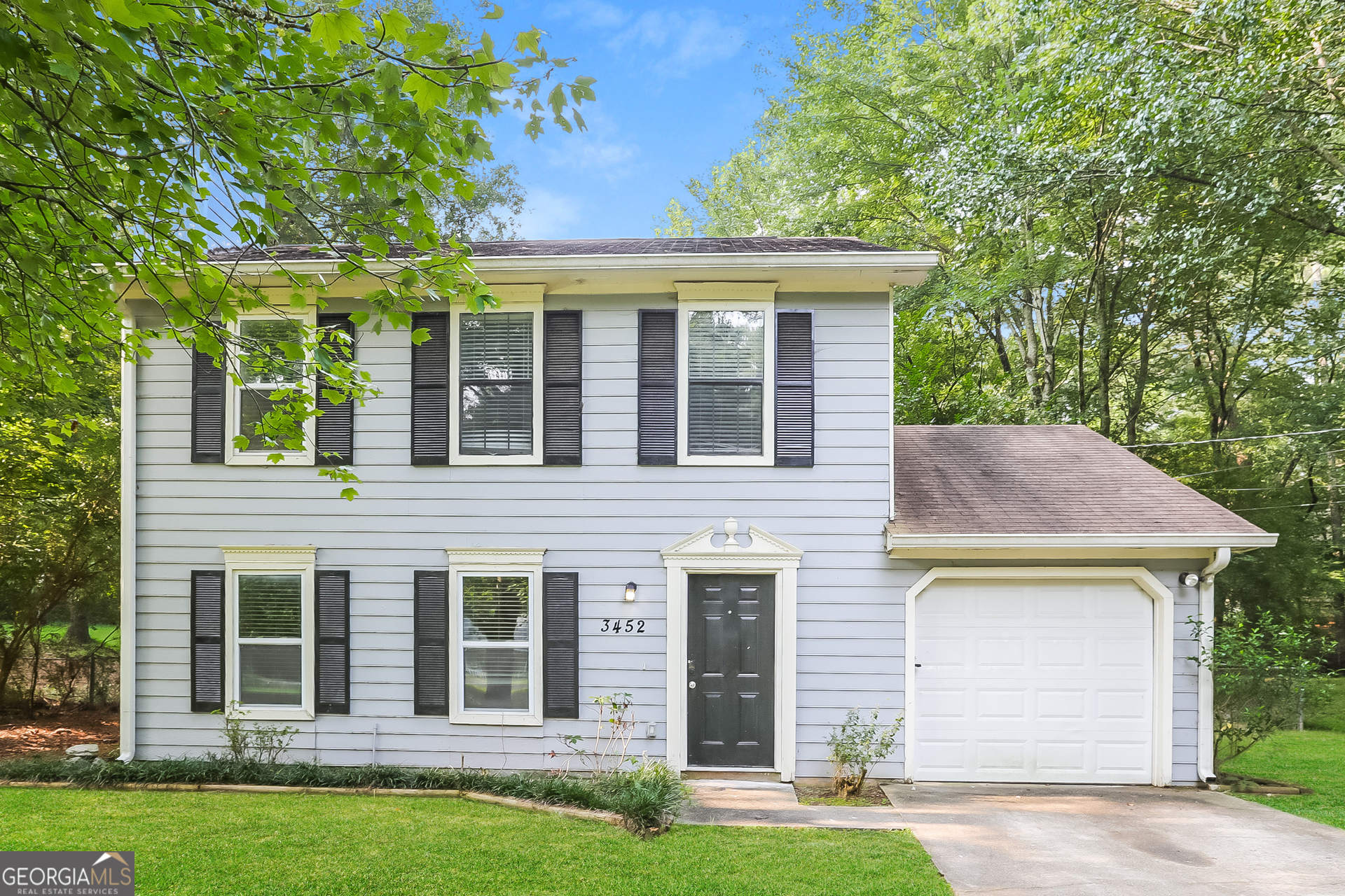 a front view of a house with a garden and yard