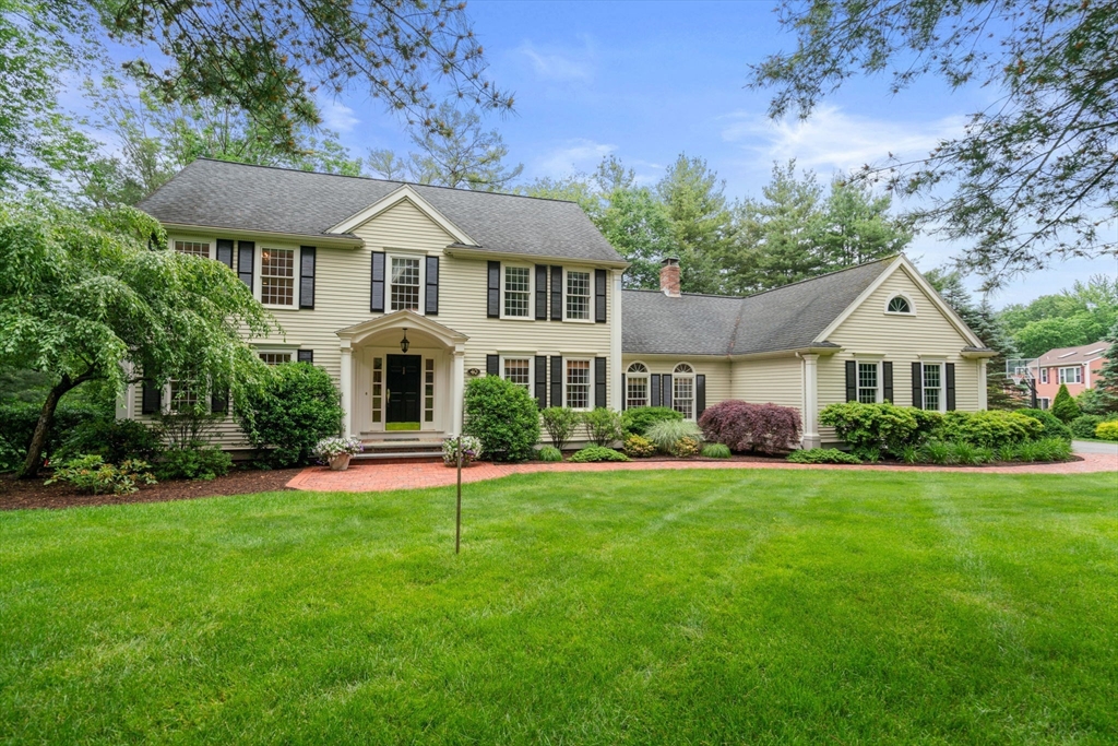 a front view of a house with a yard and trees