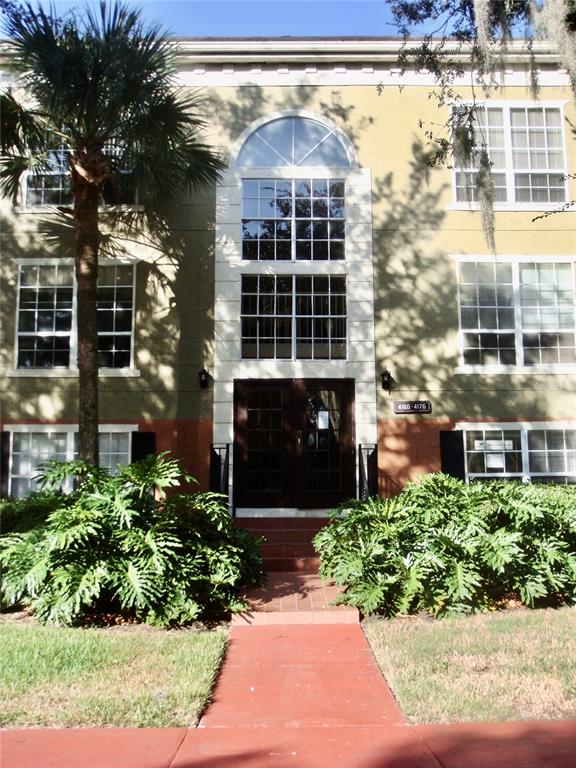 a front view of a building with a garden