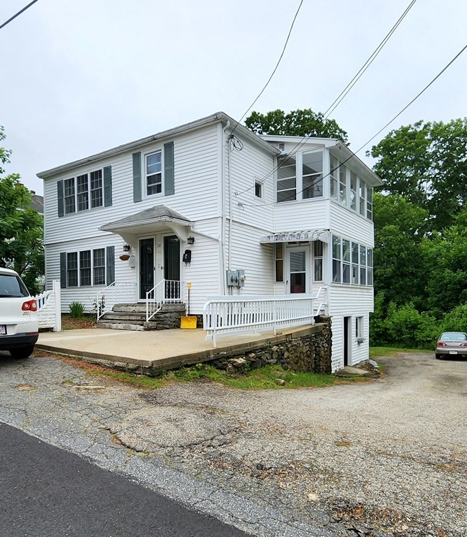 a view of a white house with a yard and plants