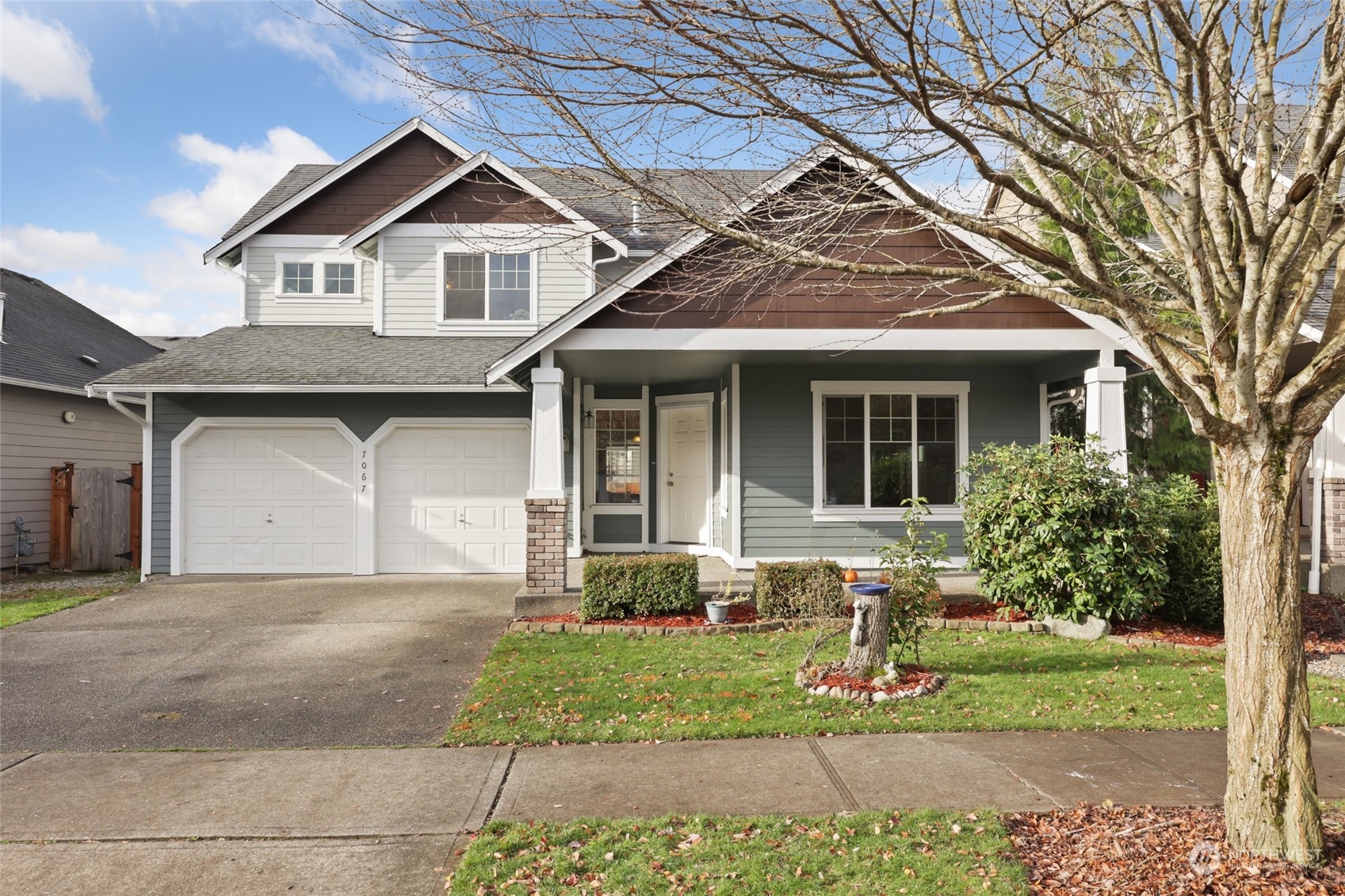 a front view of a house with a yard and potted plants