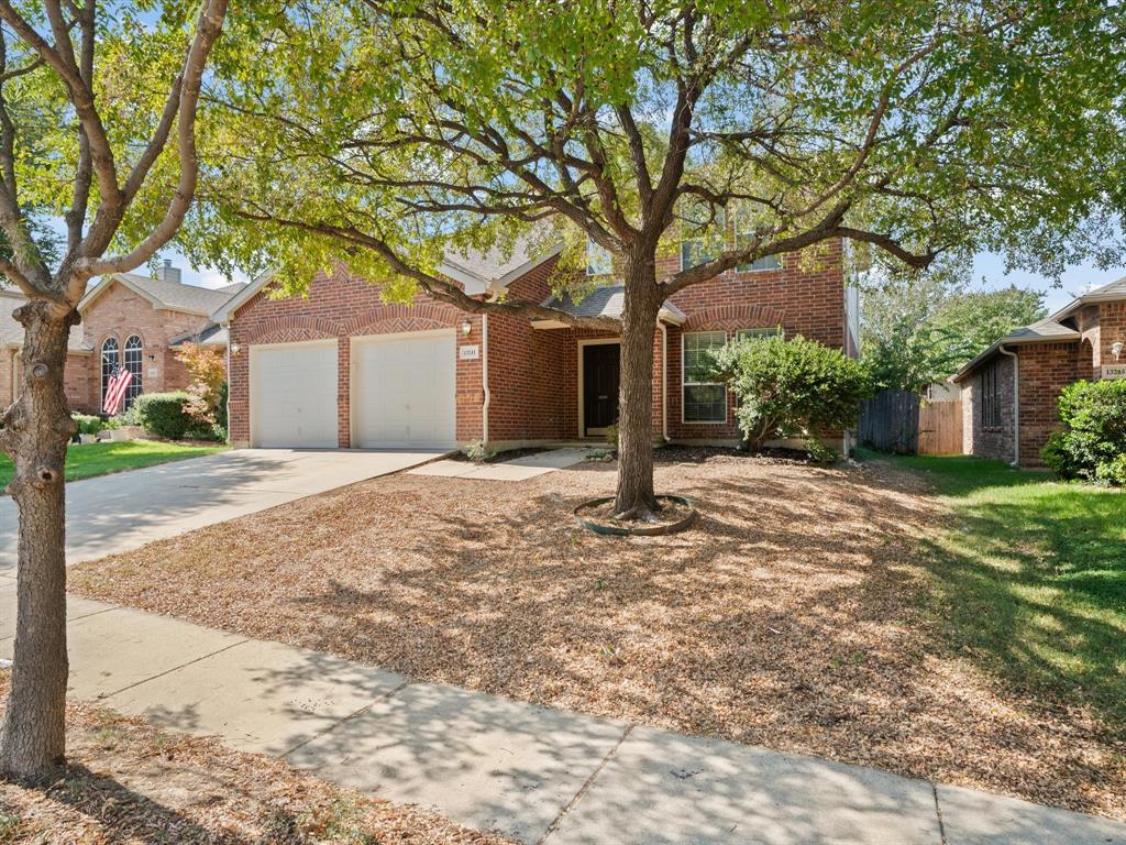 a backyard of a house with large trees and brick walls