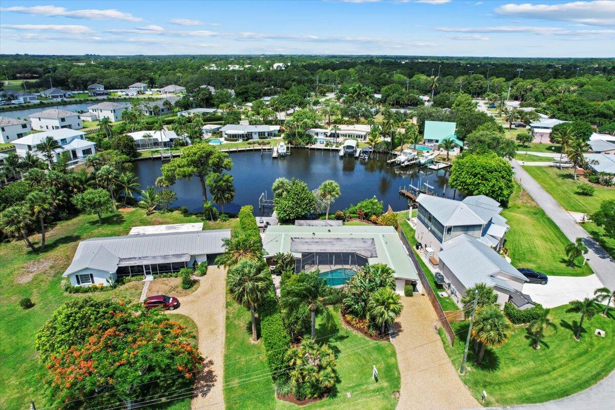 an aerial view of a house with a garden and lake view