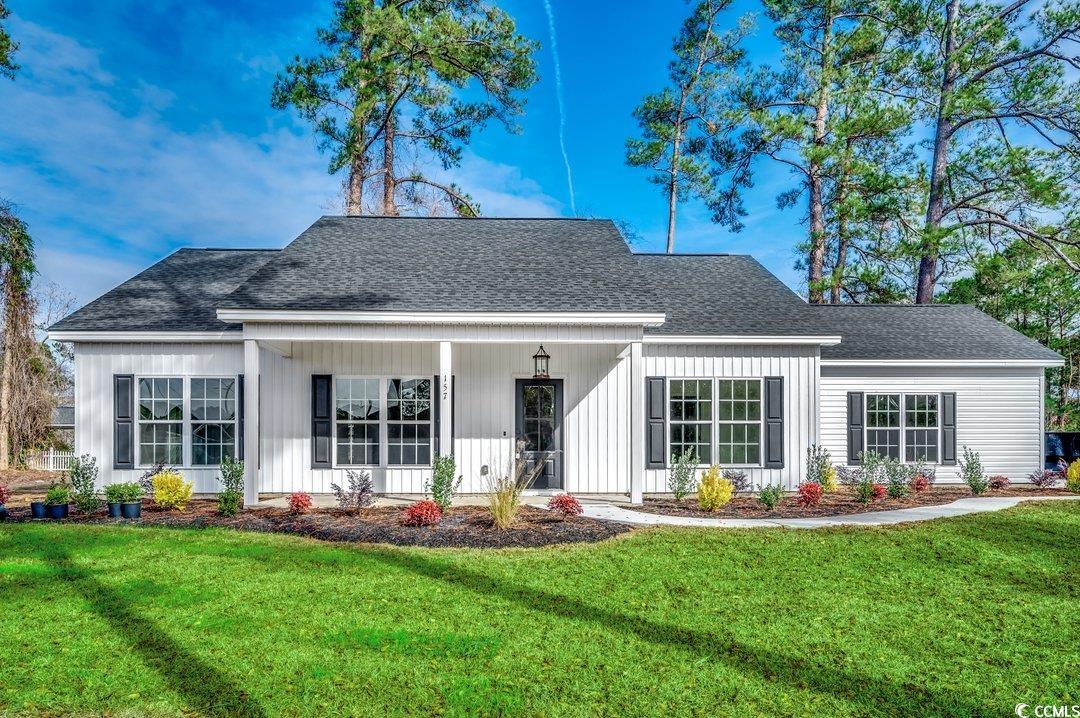 Back of house featuring covered porch and a lawn