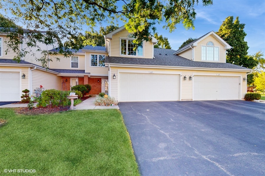 a front view of a house with a yard and a garage