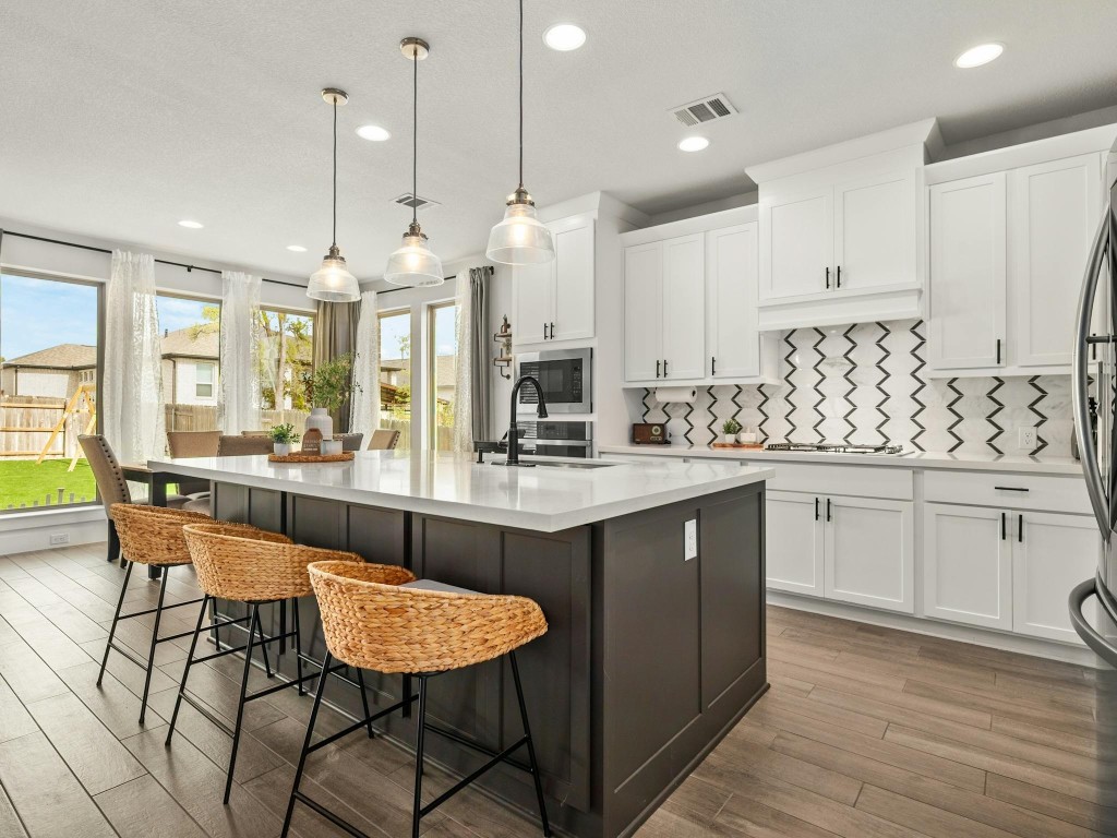 a large kitchen with a counter space and a wooden floor