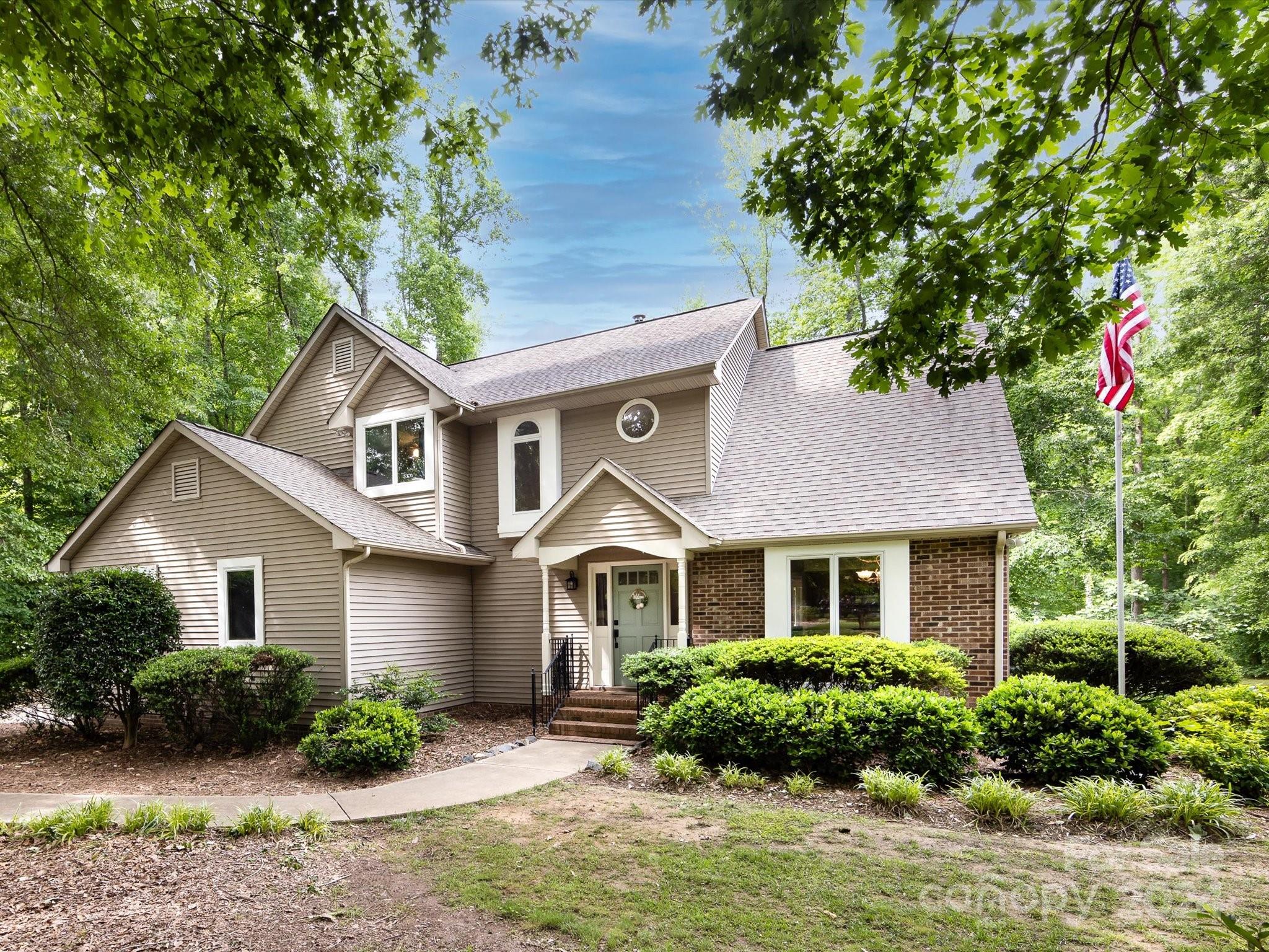 a front view of a house with a yard and potted plants