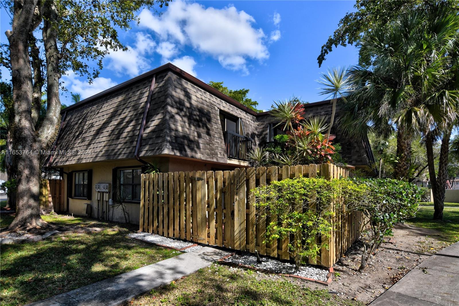 a view of a house with wooden fence