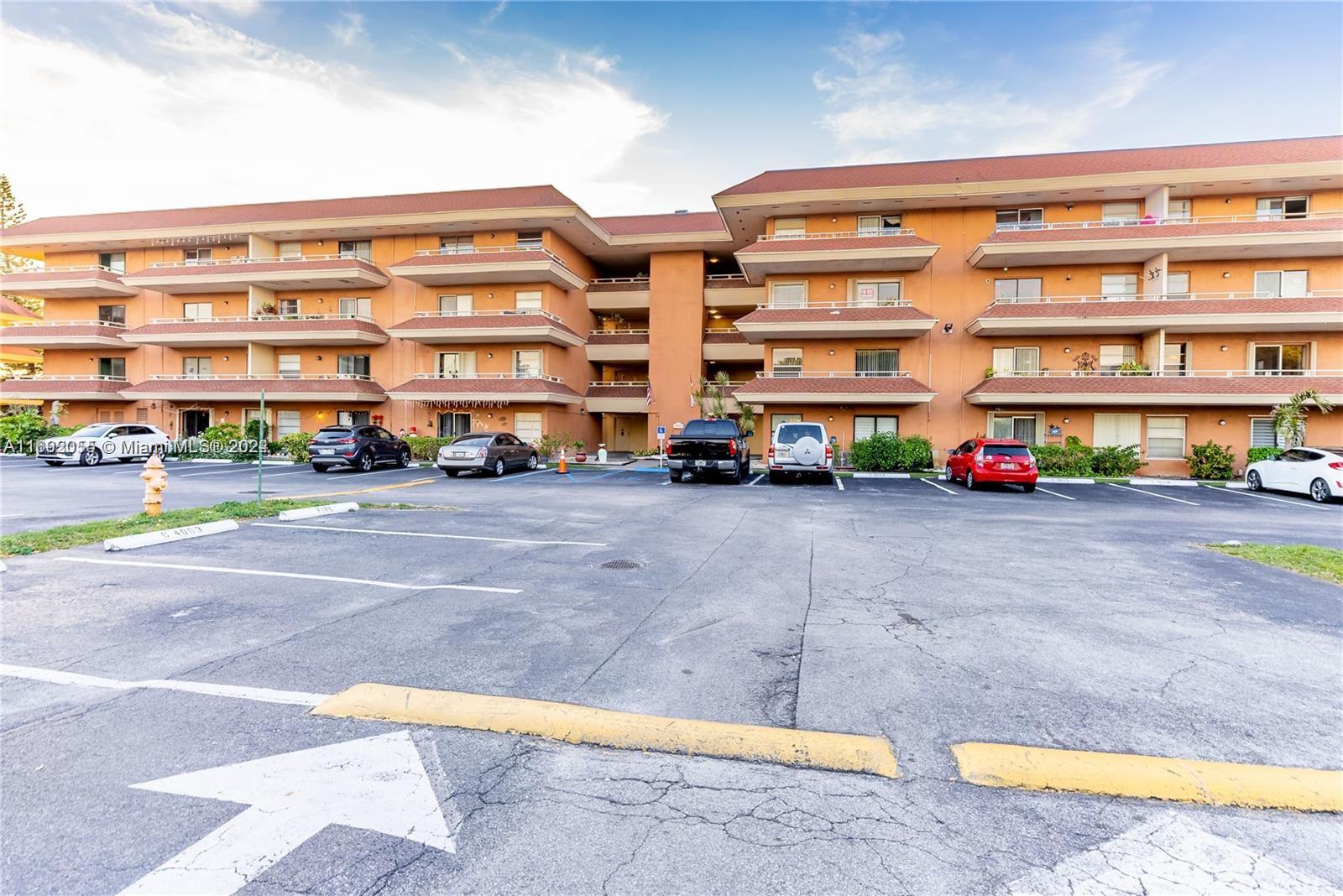 a front view of a building with cars