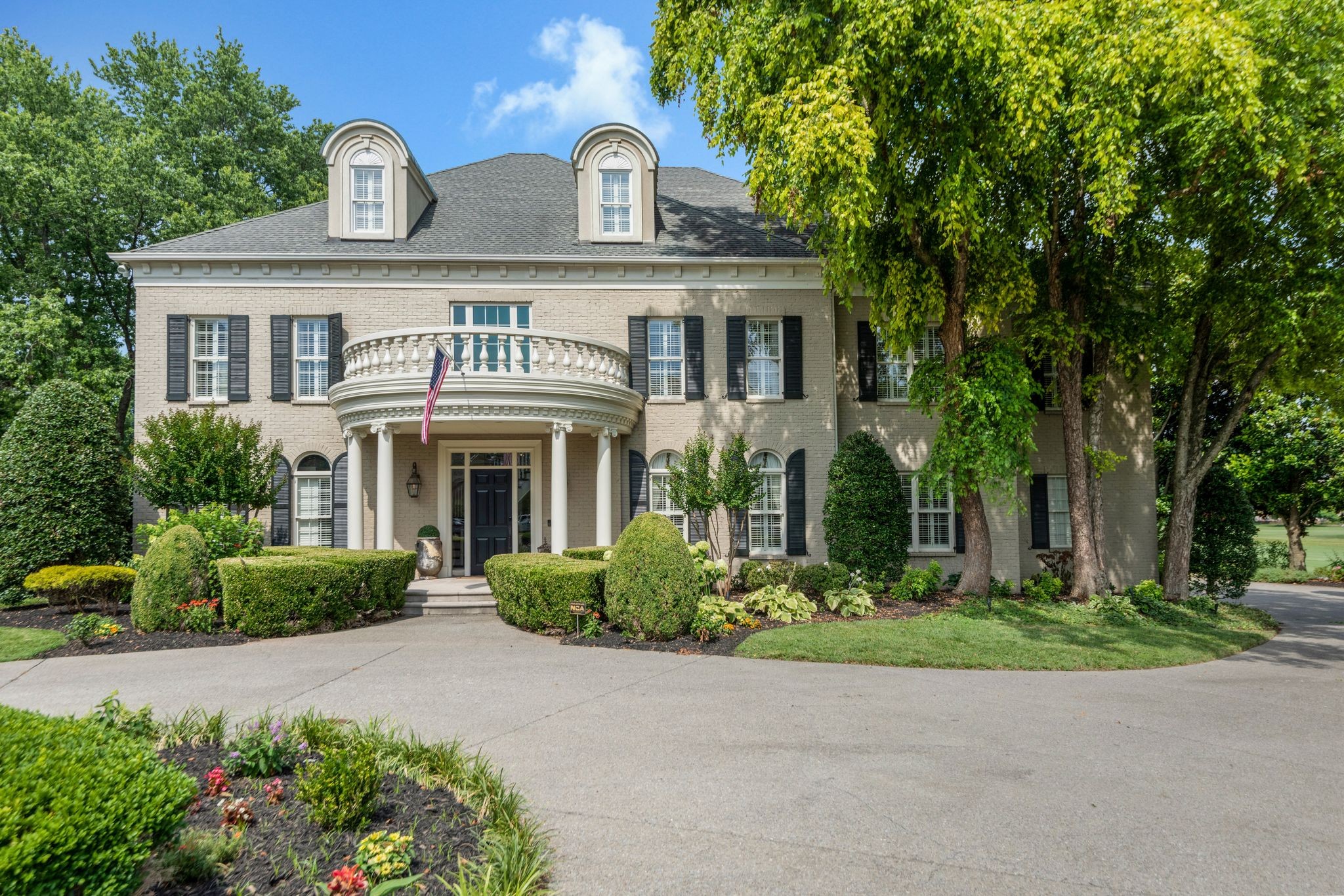 a front view of a house with a yard and trees