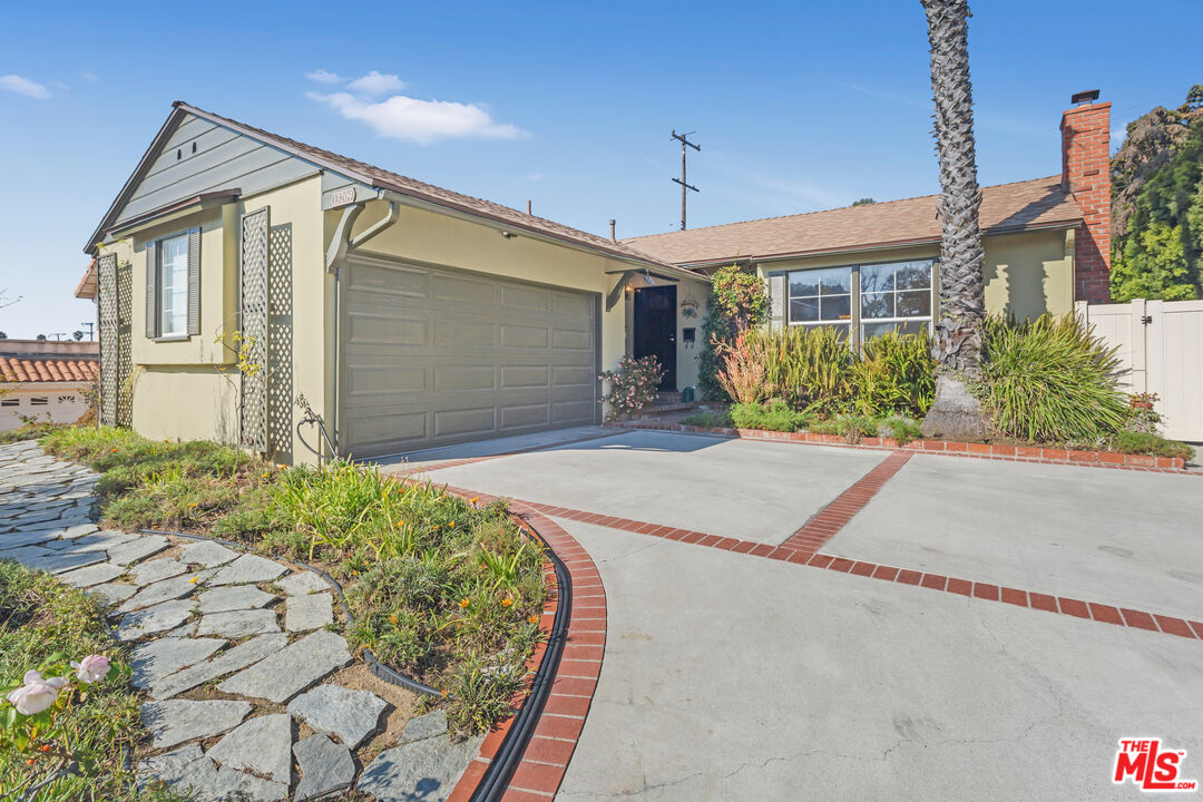 a front view of a house with a yard and potted plants