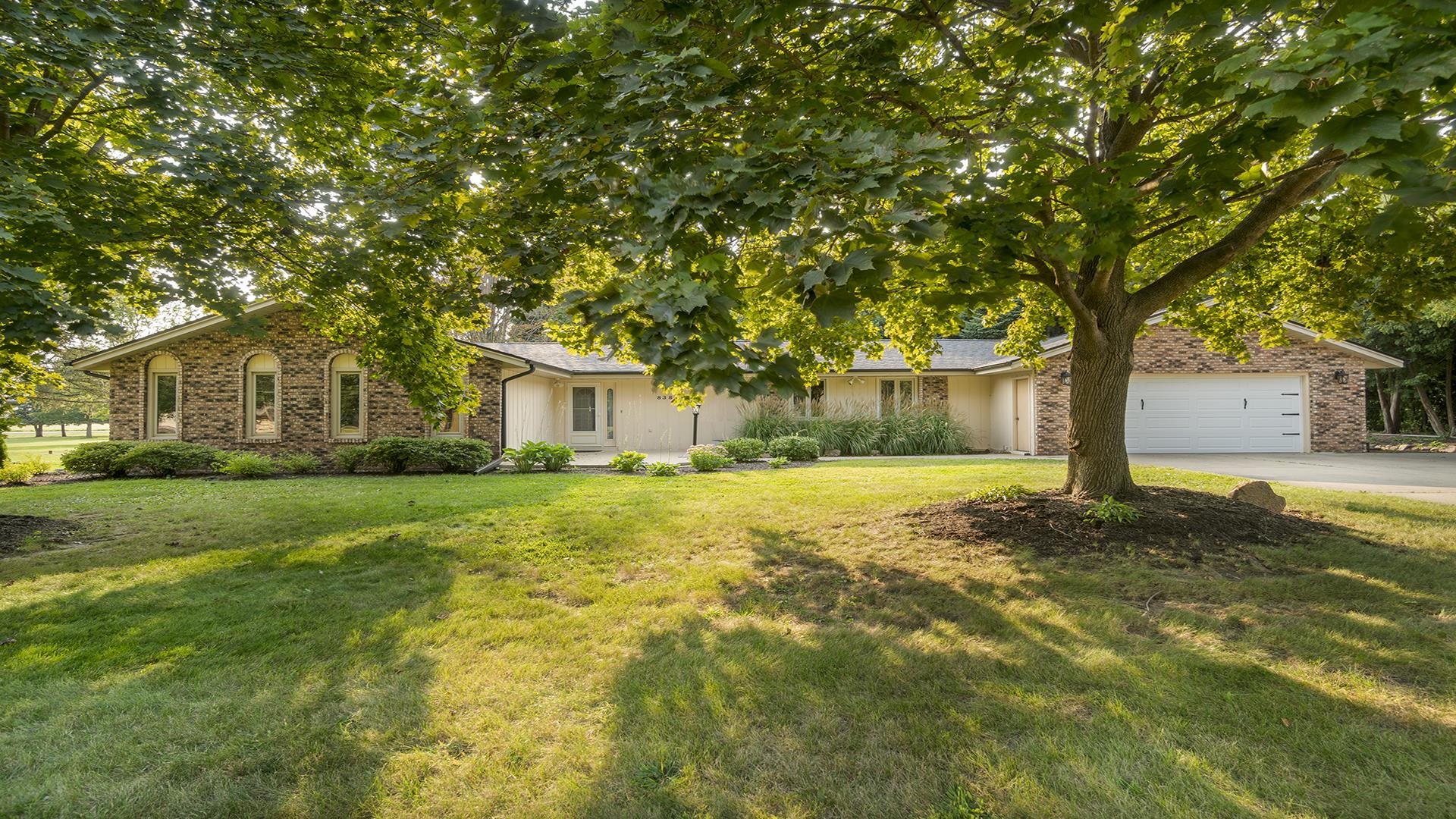 a front view of a house with yard and green space