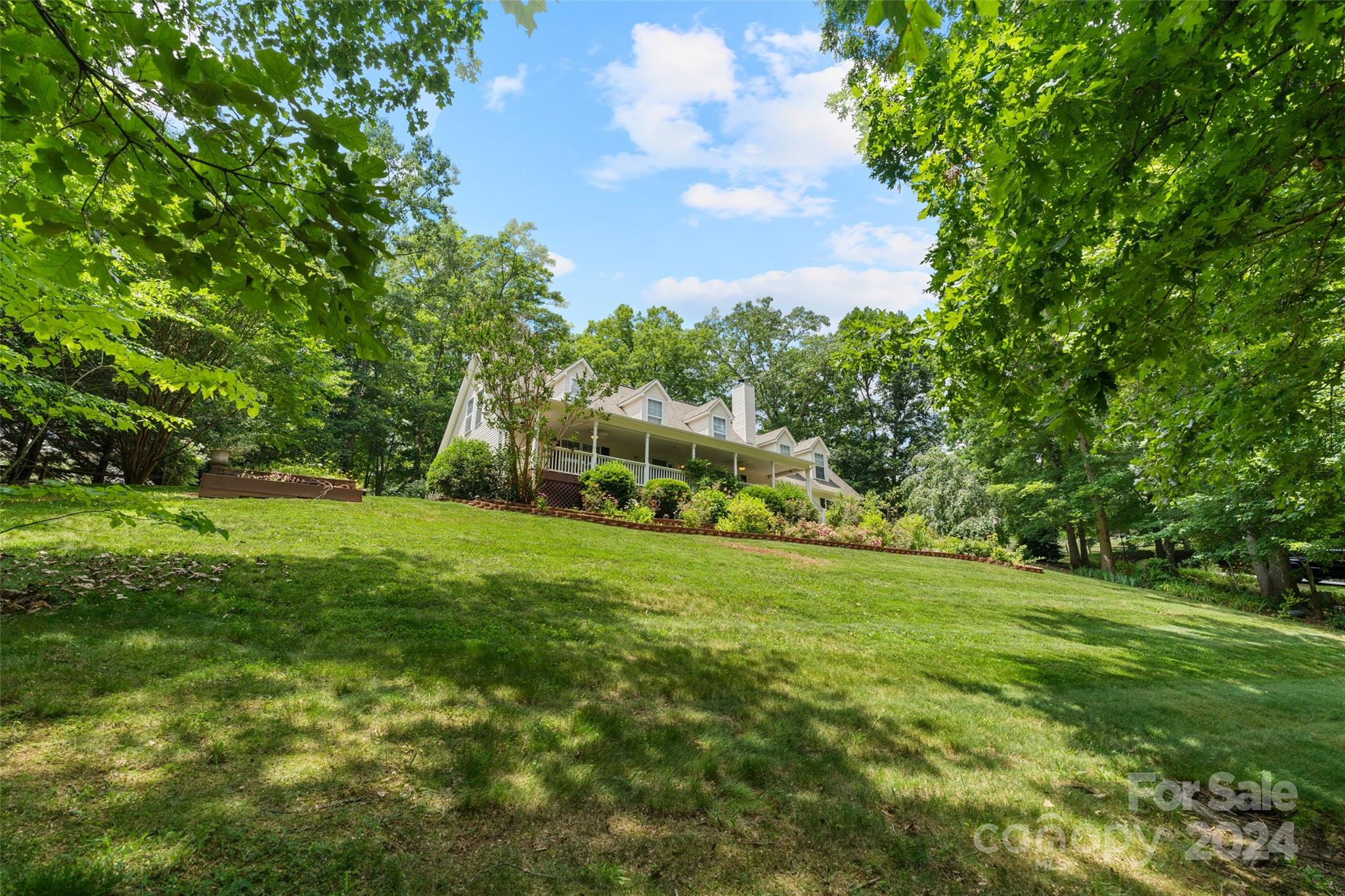 a view of a grassy field with trees in the background