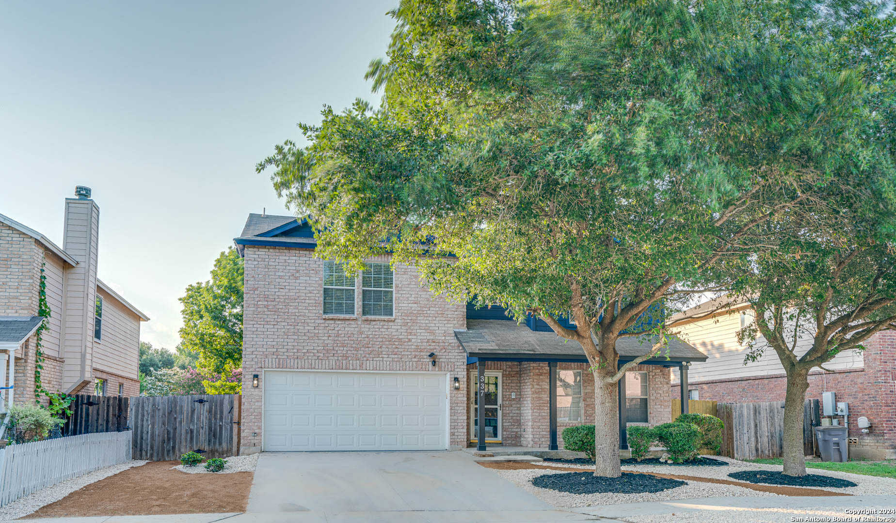 a front view of a house with a tree