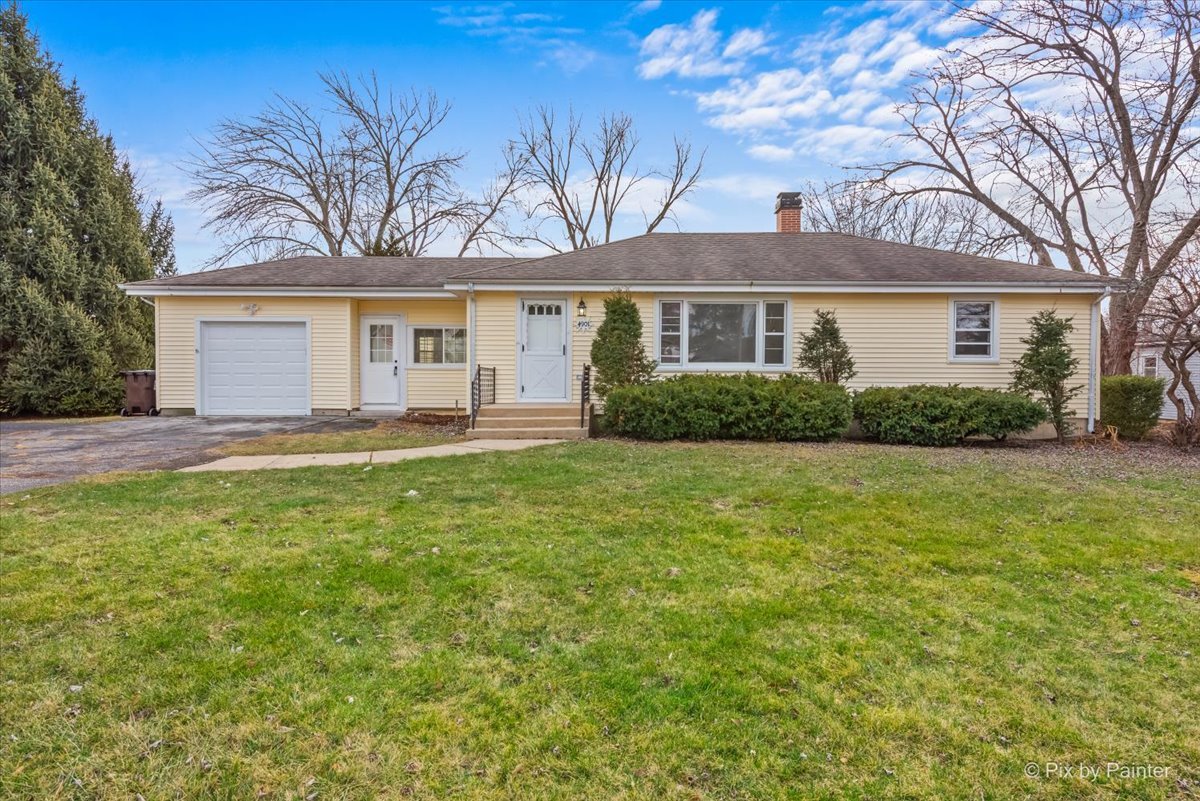 a front view of a house with a yard and trees