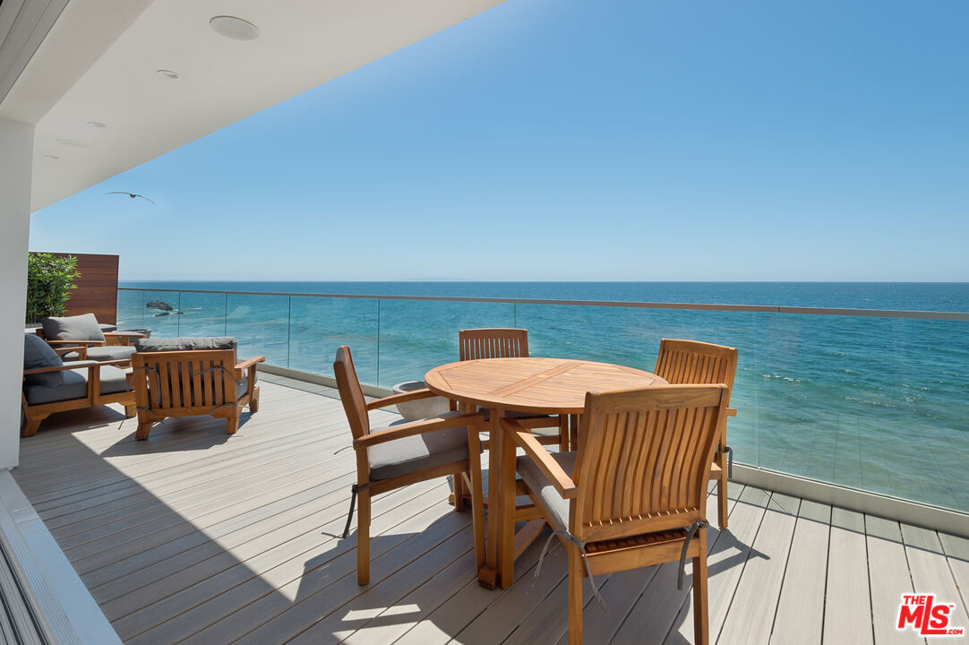 a view of a roof deck with table and chairs