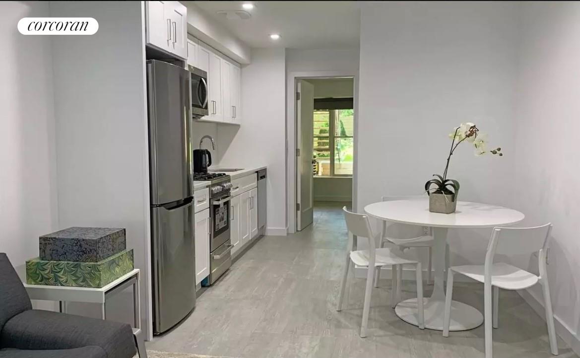 a kitchen with a sink chairs and refrigerator