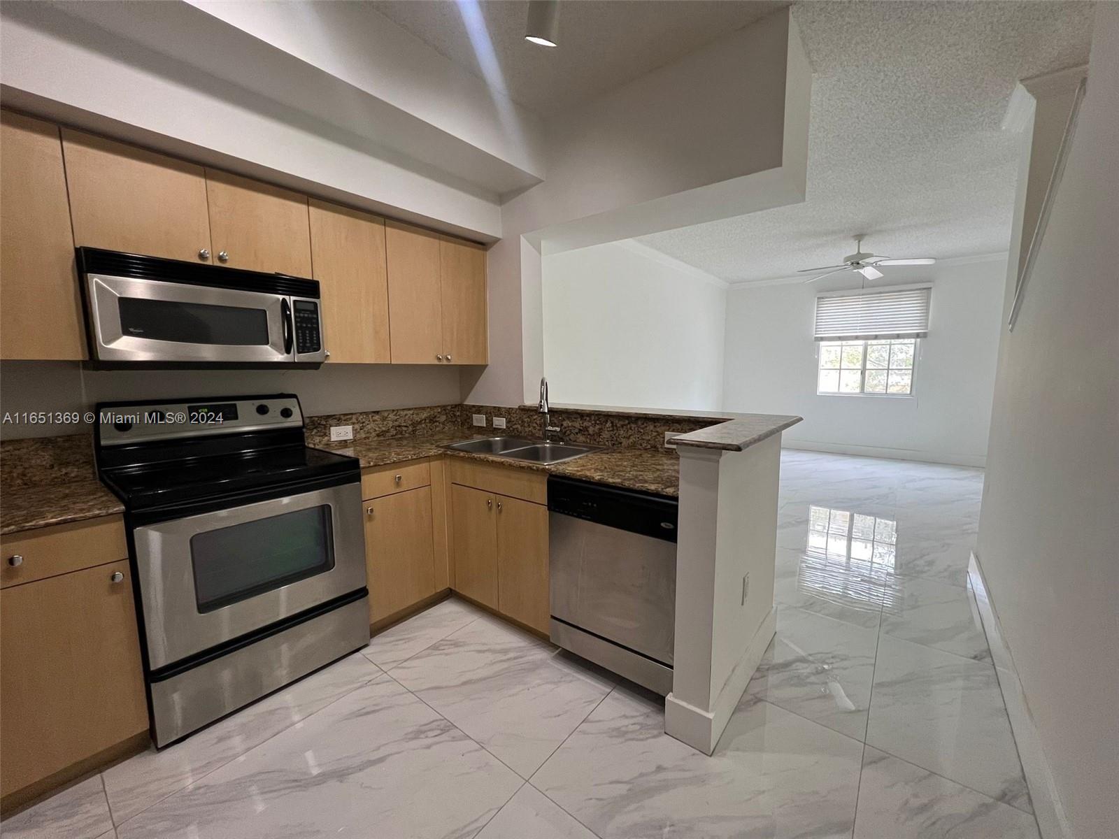 a kitchen with granite countertop a stove and a microwave