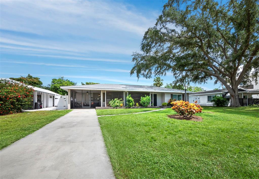 a front view of a house with a yard and trees