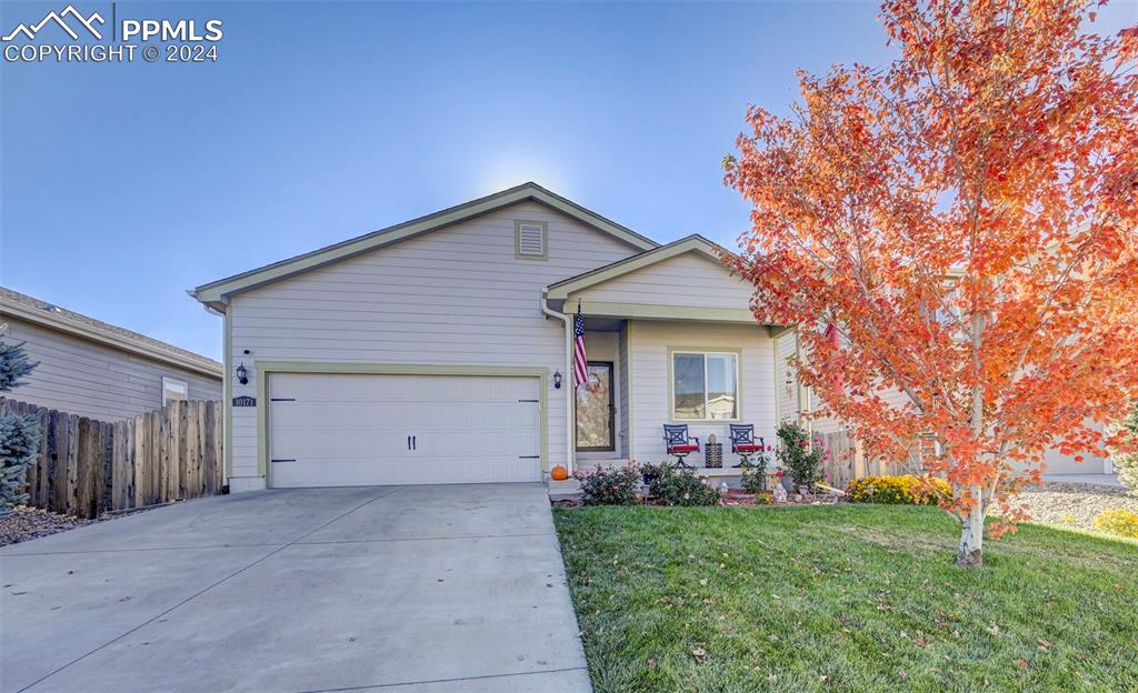 Ranch-style home featuring a front yard and a garage