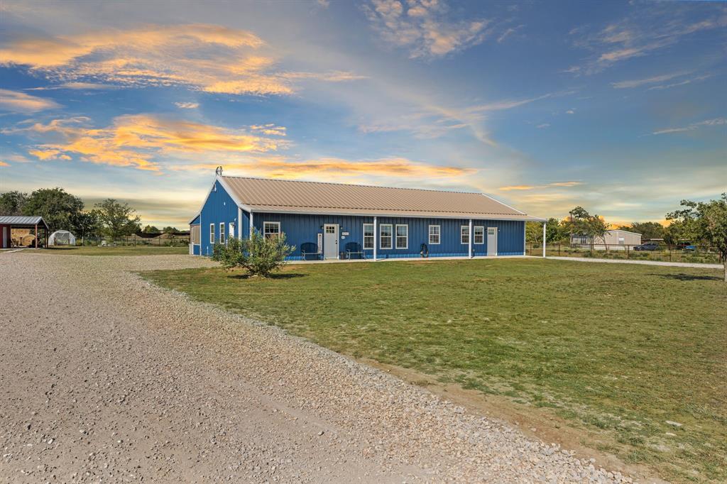 a front view of house with yard and lake view