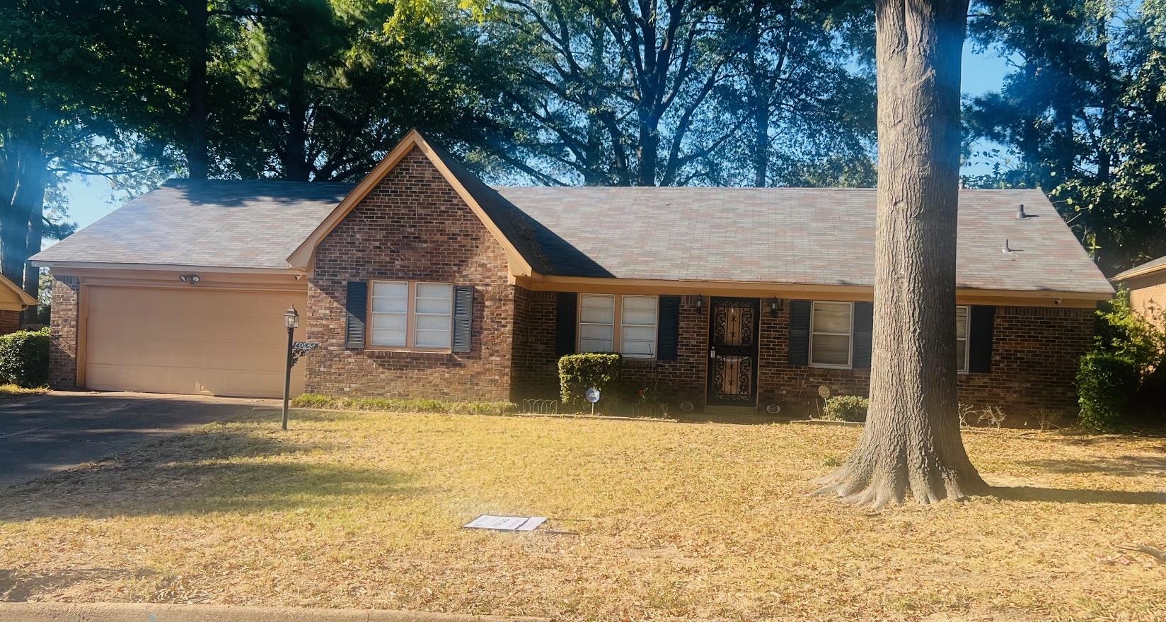 View of front of house featuring a front lawn and a garage