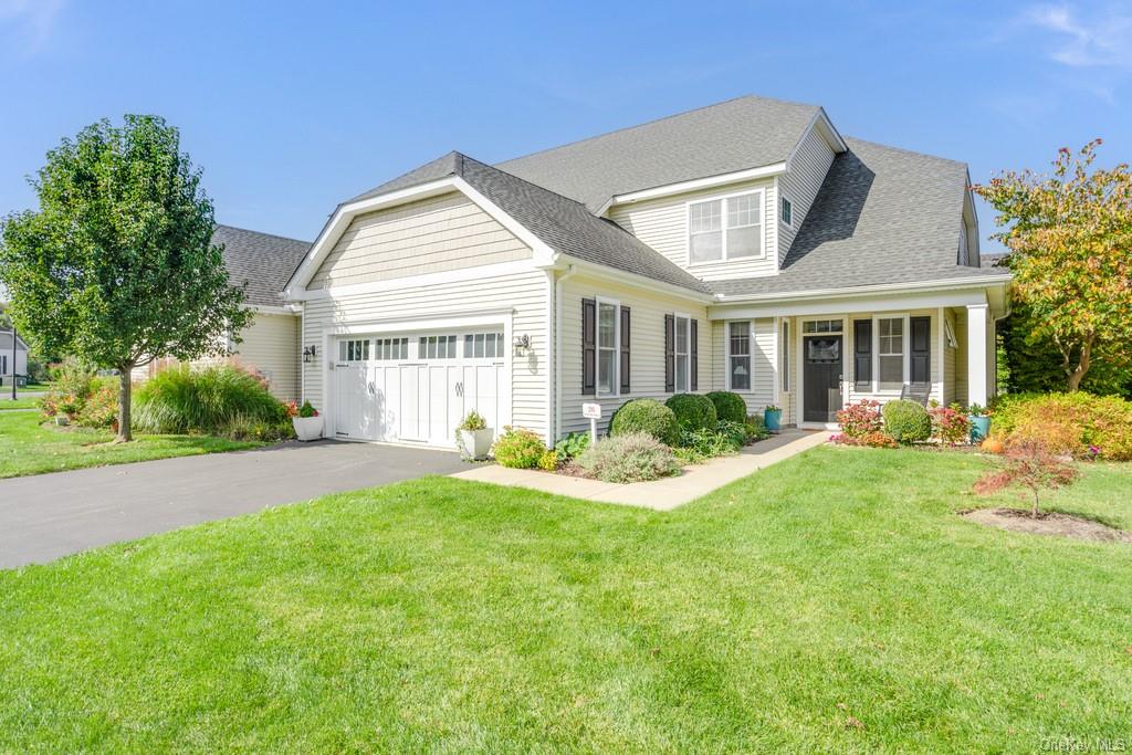 View of front of property featuring a front lawn and a garage