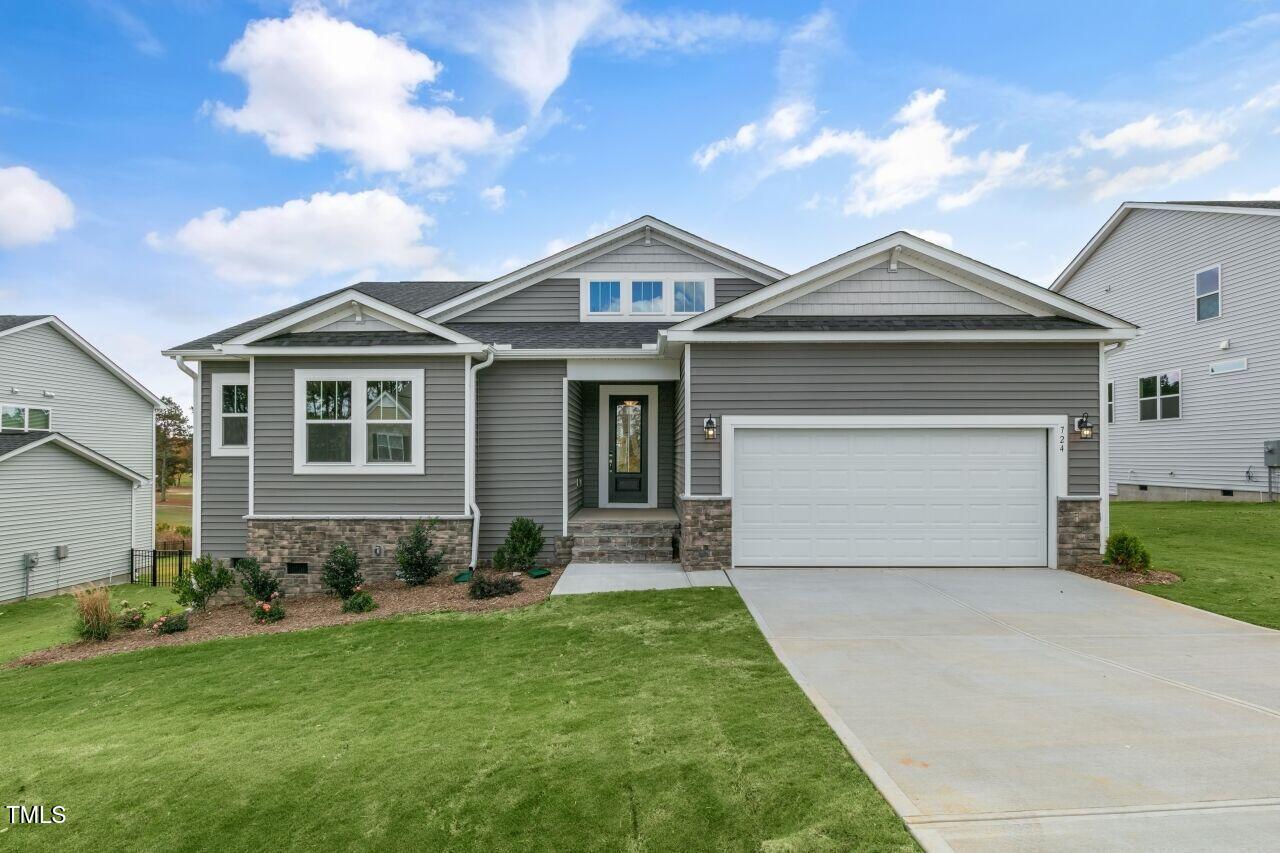 a front view of a house with a yard and garage